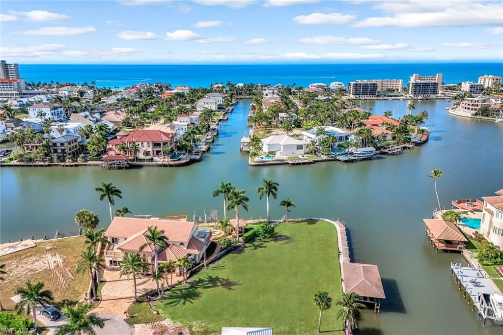 Remarkable point lot with . 45 of an acre presents an extraordinary westerly position with more than 180 ft of wrap around waterfront! One of the largest waterfront sites in all of Vanderbilt Beach.  Boasting an incredible sense of space, privacy and breathtaking wide water views. Positioned at the end of a quiet cul-de-sac, the property captures a spectacular panorama of intersecting waterways, swaying palms and magnificent western sunsets. The expansive waterfront provides tremendous flexibility for creating an outdoor living environment and dockage for multiple vessels. An existing grandfathered boathouse is ideally positioned to preserve the views from your future residence an increasingly rare waterfront advantage.  For the boating enthusiast, direct Gulf access places the waters of Southwest Florida at your doorstep. Spend the day cruising the Gulf, fishing or exploring nearby waterfront destinations.
Beyond the waterfront, enjoy the exceptional coastal lifestyle that makes Vanderbilt Beach one of Naples’ most desirable destinations. The beach, The Ritz Carlton, LaPlaya Beach & Golf Resort, Mercato, Whole Foods Market, tennis, pickleball and outstanding dining including The Turtle Club, BALEEN, DUSK and Gumbo Limbo, and you could join the new Paraíso Beach Club which are all just minutes away. Fully engineered plans by award winning MHK Architecture may also be available, offering the potential for significant time savings and an accelerated path toward construction of your dream home. 
Imagine your dream home with sparkling water views and stunning nightly sunsets.  Rarely does a homesite combine this much land, waterfront, privacy, boating access and preferred sunset exposure in one exceptional setting. An extraordinary canvas for a custom residence designed around the very best of Naples waterfront living.