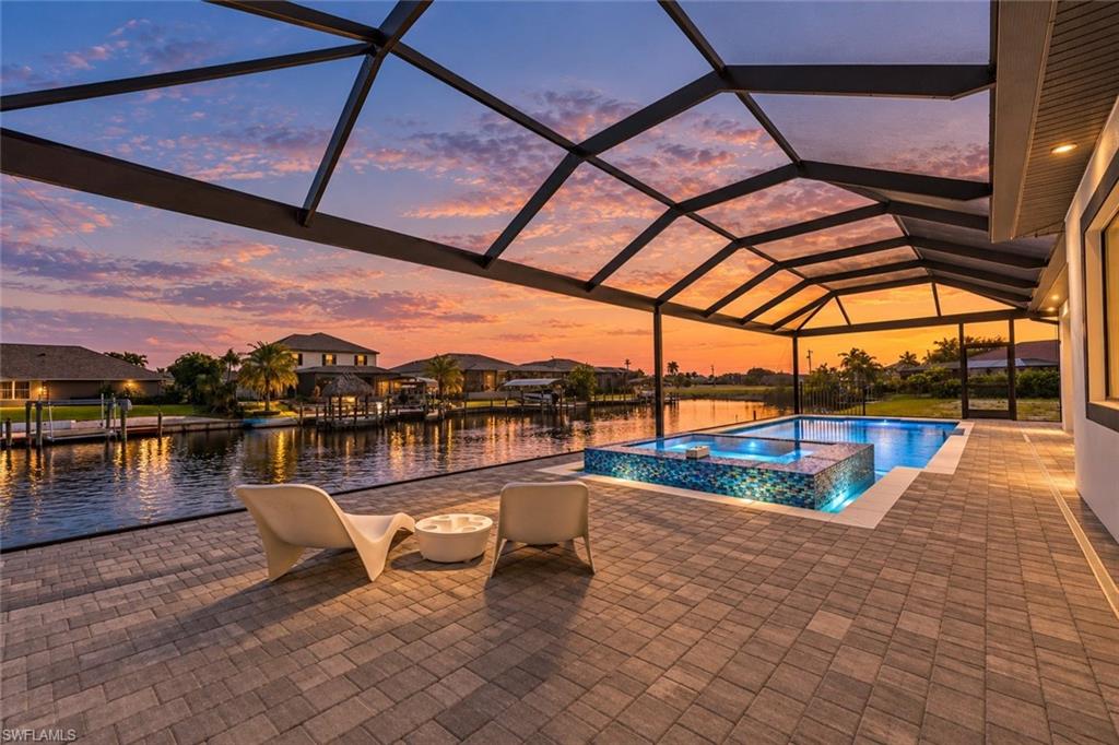 One or more photo(s) has been virtually staged, AI generated or rendered.  Imagine waking to morning light dancing across the canal, savoring coffee beside the pool, and ending the day entertaining under your covered lanai. Welcome to 817 NW 38th Ave, a BRAND-NEW 2026 luxury Gulf-access residence where architecture, comfort, and the Southwest Florida waterfront lifestyle come together.

Spanning 2,448 square feet with 4 bedrooms, 3 bathrooms, a den, and a 3-car garage, the home makes a memorable entrance with its striking facade, paver driveway, and elegant exterior lighting. Inside, Venetian plaster accentuates the entry and custom TV entertainment wall. Tray ceilings with soft cove lighting, large-format tile flooring, streamlined linear AC vents, designer lighting, and dramatic black-framed sliding glass doors create an inviting, contemporary atmosphere. Remote-controlled zebra blinds dress the windows and patio doors, while hanging bedside pendants bring boutique-hotel style to the bedrooms.

Designed for gathering, the great room opens to a kitchen featuring contrasting cabinetry, a generous island, walk-in pantry, wall oven, pot filler, and wine cooler. Expansive sliding doors connect the living spaces to the pool and canal beyond.

The primary suite is a serene retreat with two walk-in closets featuring custom cabinetry and glass doors. Its spa-inspired bathroom offers a multi-jet shower with a waterfall-style rain shower, separate jetted soaking tub, dual sinks, and the convenience of smart toilets throughout the home.

Outside, enjoy a spacious paver pool deck, electrically heated pool, and raised mosaic-tiled spa, framed by views of a wide waterfront canal. The covered outdoor living area features a warm wood-look ceiling, ceiling fan, and built-in outdoor kitchen, perfect for relaxed afternoons or memorable evenings with friends. An outdoor shower, screened enclosure, east-facing rear exposure, and bridge-restricted Gulf access complete the waterfront experience. Impact-resistant windows and doors, a tile roof, and no HOA fees add practical appeal.

The location makes this opportunity even more compelling. Northwest Cape Coral is welcoming exciting new amenities, including the newly opened Tropicana Park with waterfront recreation and kayak access. Nearby Sirenia Vista Park offers opportunities to explore nature, watch manatees, and enjoy the area's waterways. The planned Seven Islands Gulf Gateway Resort & Marina Village is envisioned to introduce waterfront dining, shopping, hospitality, and public recreational spaces, while the Cape Coral Grove development along Pine Island Road is planned to bring additional shopping, restaurants, and entertainment to the area.

This is more than a beautifully designed new home. It's an opportunity to enjoy waterfront living, exceptional comfort, and a growing Southwest Florida community, all from a place you'll love coming home to.