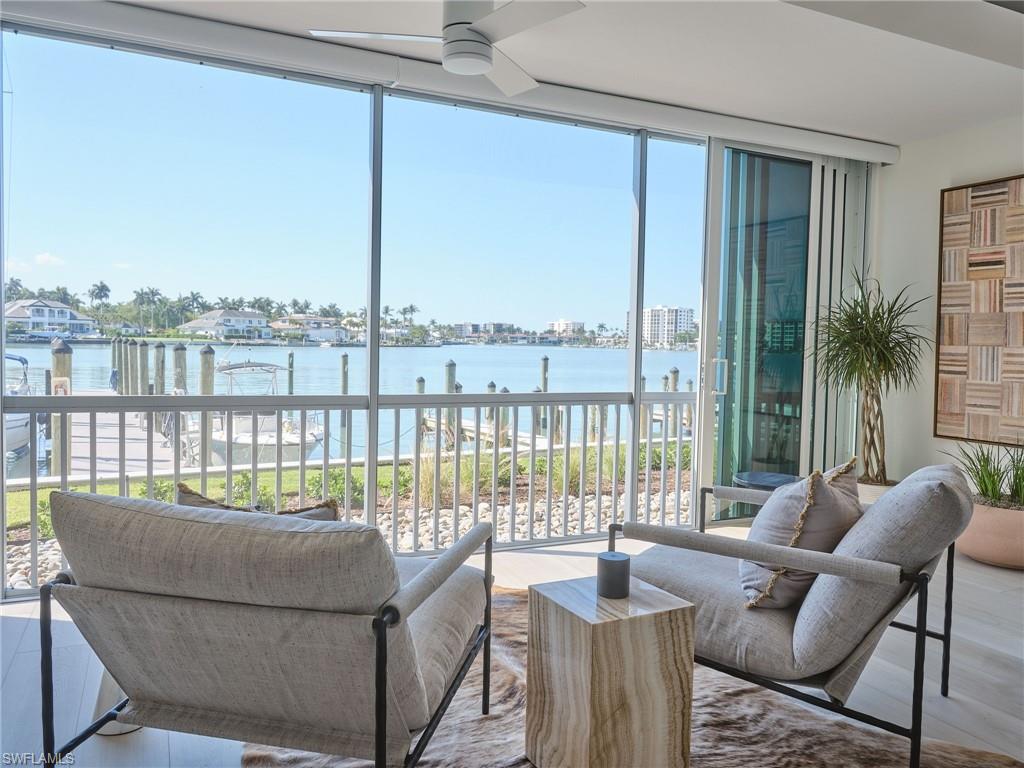 Welcome to your waterfront home on Moorings Bay - long bay views, true southern exposure, and direct Gulf access with NO bridges. This rarely available 2-bedroom, 2-bath, first-floor end unit sits right on the water at Moorings Bay Apartments, one of only 24 residences in the heart of The Moorings. Open the sliders and the great room, dining area, and 22-foot lanai all look straight down the bay - perfect for morning coffee or watching the boats head out to the Gulf of America. The custom Eggersmann kitchen is the centerpiece - waterfall Quartzite island, panel-ready appliances, and a separate bar with lit glass cabinetry and a beverage fridge for entertaining. Both bedrooms are large and bright, the primary suite has a walk-in closet, and each bathroom is custom with Quartzite counters, wood vanities, and tiled walk-in showers. In-unit laundry, too. Offered furnished. Step outside to the community pool overlooking the bay and the tiki hut right on the docks - with boat slips available for lease, you’re only a short ride to open water. Moorings Bay Apartments recently renovated all common areas and infrastructure, with professional tropical landscaping throughout. Best of all - EVERYTHING inside is done. This unit was taken down to the studs and rebuilt: new plumbing, electrical, HVAC, drywall, doors, trim, flooring, and hurricane impact windows, plus a whole-home lighting system and smart-home integration.  Nothing left to do but move in. Just minutes from Naples’ beaches, Fifth Avenue South, and Waterside Shops - schedule your private showing today!