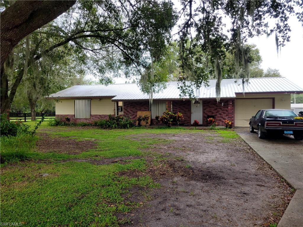 EQUESTRIAN DELIGHT: This versatile 4.79-acre LaBelle property on Howard Road offers an exceptional blend of equestrian amenities, oversized storage, rural infrastructure, and recreational utility. Features riding arena with engineered clay-and-white-sand footing, a center-aisle barn with four stalls, tack/feed room, pasture space, and potential to expand to 6+ stalls, subject to verification. A tall-clearance sailboat barn with an independent 220-amp electrical panel provides ideal storage for boats, RVs, trailers, and large equipment, while driveway access supports side-by-side RV or trailer parking. Rural utility features include two wells serving the residence and barn/pasture separately, plus dual septic systems including a standalone laundry septic tank. The acreage also includes a half-acre pond. 
The 2BR/2BA home had some updates and ready for your design. Features a metal roof, spacious garage with Level 2 EV charger, built-in entertainment speakers, working chimney, Carrier A/C, and a renovated kitchen with ceiling-height eggshell Shaker cabinets, stainless steel appliances, Calacatta quartz counters, backsplash, peninsula, and a spacious pantry. A bright family room with a wall of windows and a bonus flex room.
Property is currently occupied. Some images have been digitally altered to add/remove furniture.