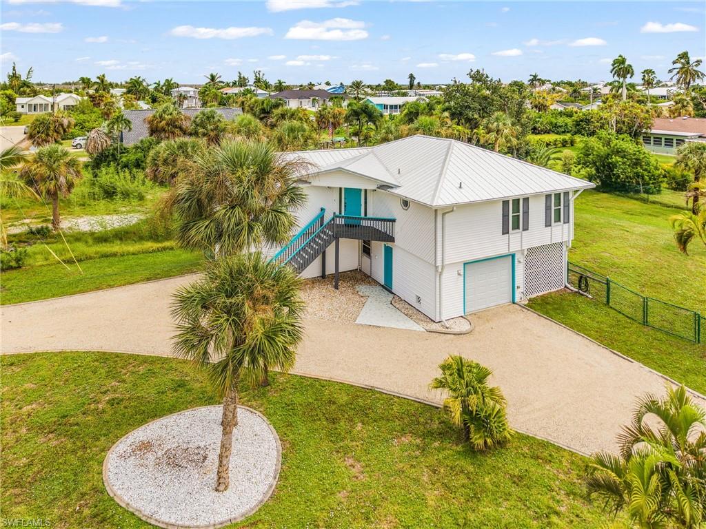 Welcome to Pine Island! Bring your boat, trailer, camper, and a toothbrush! Enjoy a relaxed lifestyle in the heart of beautiful St. James City! This TURNKEY furnished elevated stilt home sits on almost one-third of an acre and offers a wonderful combination of space, privacy, accessibility, and location.

The home features a fenced backyard with a double gate, making it easy to bring in a boat, RV, trailer, or other recreational toys. With no HOA and no restrictions on storing boats or RVs, you have the freedom to truly enjoy your property and the Southwest Florida lifestyle.

St. James City is golf-cart friendly, and you’re just a quick ride from local restaurants, bars, and shopping. The neighborhood is perfect for walking the dog, riding bikes, or simply enjoying the laid-back pace of island living. The St. James City Civic Center is less than a block away, offering a park and a variety of activities and entertainment for both children and adults.

This home is also designed with accessibility and comfort in mind. An exterior lift provides convenient access from the ground level to the spacious upstairs screened porch, making the home handicap accessible. The home offers two screened porches—one conveniently located off the garage and another upstairs where you can truly take advantage of the beautiful Florida weather. The upstairs porch faces east and offers must-see sunrise views. Sliders open from the porch into the bedroom, living room, and dining room, creating a wonderful connection between indoor and outdoor living.

Inside, the main living area thoughtfully separates the bedrooms, providing additional privacy for family and guests. Recent updates include a new metal roof and electrical panel with new receptacles in 2023, along with hurricane windows and a hurricane-rated garage door for added peace of mind. The front staircase and rear steps feature durable composite decking for easy maintenance.

With nearly one-third of an acre, a fenced yard, no HOA restrictions, great accessibility, multiple outdoor living spaces, and a location close to everything St. James City has to offer, this is a home that makes it easy to embrace the island lifestyle.