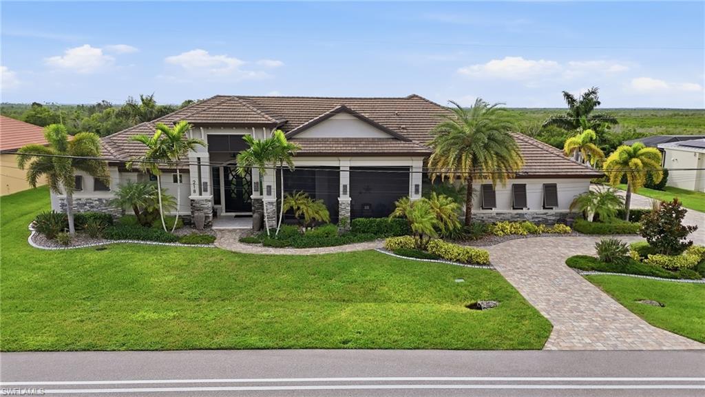 Welcome to this ultimate direct sailboat gulf access five star resort style estate home. Experience unmatched coastal grandeur in this exquisitely designed waterfront master piece. Situated on the "North Spreader" with views of natural mangroves and beautiful western sunsets. The home makes a commanding statement from the street, taking full advantage of its wide 160 ft frontage (22,500 sq ft lot). The circular driveway leads to a spacious air conditioned, epoxy finished 3 car garage. Designed with both grand entertaining and comfortable family living in mind, the home is being offered fully and beautifully furnished with a curation of tasteful high end finishes and upgrades galore. This sprawling layout features 5 bedrooms, 3.5 elegantly appointed baths, walk-in pantry, with custom shelving and offers an effortless turnkey life style for the most discerning buyer. From the moment you approach the grand entrance - you are welcomed by a front covered patio with electric screen and double set of custom double iron and glass front doors. You will feel enveloped in absolute luxury, especially once inside the home and see the elaborate tray ceilings and crown molding throughout. The primary suite is a true sanctuary which features access to the outdoor living space and leads into a massive en-suite bathroom with two large and separate walk-in closets. Every room at the back of the home offers waterfront views and access to the pool deck. Main living area boasts hurricane impact pocket sliders leading to a top of the line summer kitchen, dining area and living area with gas fireplace. All are protected by electric hurricane shutters. The home features security cameras installed outdoors and a commercial grade whole house propane generator. The pristine salt water pool is dramatically accented by two propane fire bowls for your evening enjoyment and is completely enclosed within an expansive screen enclosed lanai area. A boaters dream dock featuring a heavy duty lift that lifts up to 20,000 lbs plus an additional small craft lift that lifts up to 10,000 lbs for jet skies or kayaks. No expense was spared and no detail overlooked in this beautiful home. Experience the pinnacle of Cape Coral luxury by calling this your new home.