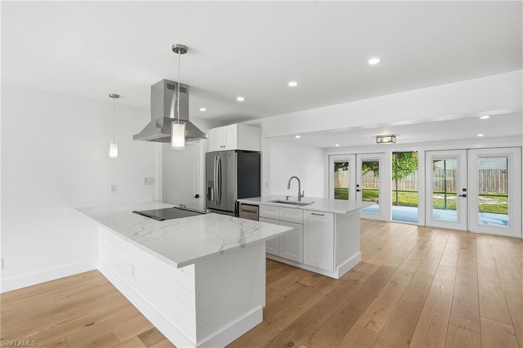 X flood zone! Tucked within a quiet, non-HOA neighborhood just one mile from the Gulf, this beautifully updated 3-bedroom, 2-bath home offers the best of Naples living. Step inside to find wide-plank white oak floors, large windows that fill the home with natural light, and a bright, inviting ambiance throughout. The sleek modern kitchen showcases white cabinetry, quartz countertops, stainless steel appliances, a striking vent hood, and ample counter space for cooking or entertaining. This residence features a versatile open layout with double living areas centered around the kitchen. Enjoy seamless indoor-outdoor living with French doors that open to a spacious screened lanai overlooking a large, fully fenced backyard—complete with plenty of room to add a pool. Both bathrooms are fully renovated, and the primary suite includes its own private side entrance—offering maximum privacy or the ideal setup for an in-law suite. Decorative exterior shutters add charm and curb appeal, while the property’s no rental restrictions and zoning for top-rated schools make it ideal for full-time or seasonal living. Ideally located just minutes from the beach, Venetian Village, Downtown Naples, Waterside Shops, and Mercato, this move-in-ready home blends style, comfort, and flexibility in one prime location.