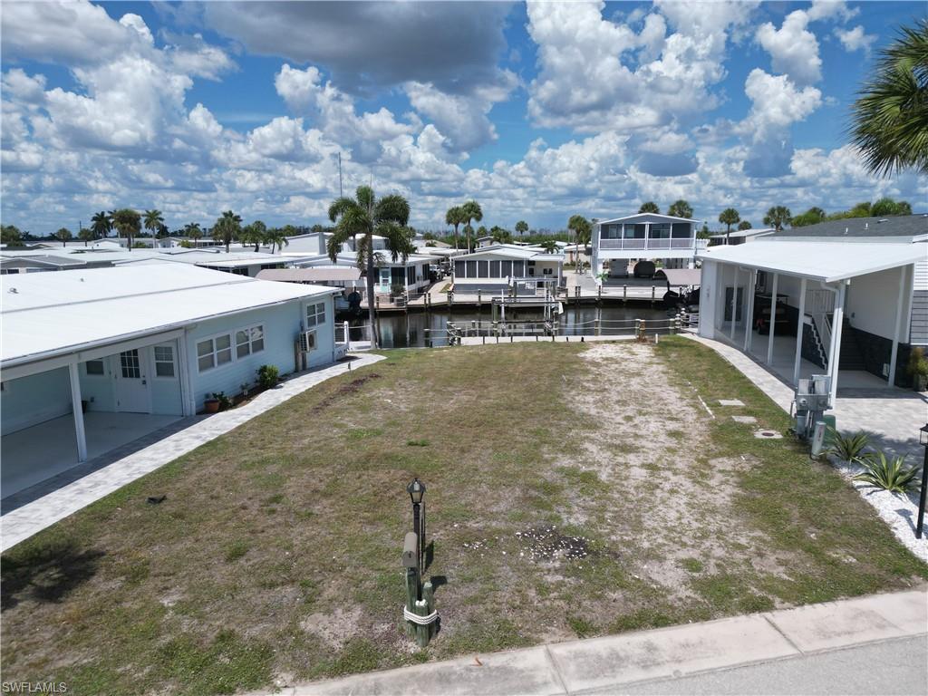 If you have been waiting for a prime Bayside Estates lot with a new dock and boat lift, wait no longer.  This lovely vacant lot in the highly desirable community of Bayside Estates has been cleared and is ready for a new buyer to purchase a state-of-the-art manufactured home and have it delivered.  Start living the retired life in Southwest Florida just minutes from Fort Myers Beach.  You can either drive or boat to the beach from this highly active 55+ community.  Many vacant lots in Bayside Estates either don't have a dock and boat lift or the dock and boat lift that is there is in need of repair or replacement---at considerable cost.  This lot however has a NEW dock and boat lift built to standards not found by most dock builders.  This lot would most appeal to those who are looking for a great value.  Come see this beautiful lot today.