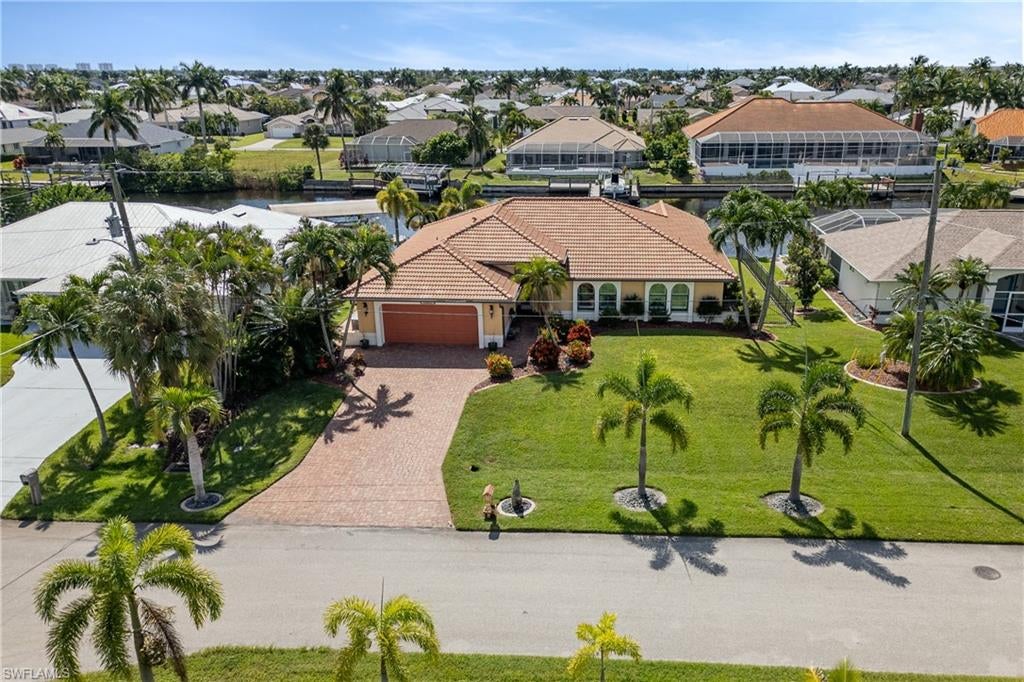 Discover the ultimate Florida waterfront lifestyle in this spacious and beautifully maintained 4-bedroom, 2-bath residence, ideally situated just off the Spreader Canal. Thoughtfully cared for and inviting throughout, this home offers a seamless blend of comfortable living and exceptional outdoor enjoyment. The true highlight is the spectacular outdoor oasis, designed for both relaxation and entertaining, featuring a stunningly appointed swimming pool, an inviting outdoor bar, and ample space within the pool cage to enjoy year-round. Boating enthusiasts will appreciate the expansive canal frontage, 13,000-pound boat lift, and wraparound dock, providing the perfect setting to embrace life on the water. Whether hosting gatherings with friends, enjoying a peaceful afternoon poolside, or heading out for a day on the boat, this property delivers the very best of the Southwest Florida lifestyle. With its exceptional waterfront amenities and beautifully maintained interior, this home is the perfect place to experience the Florida dream.