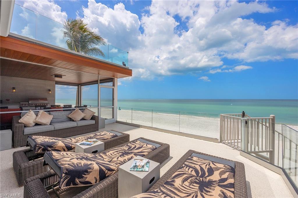 This coastal retreat offers direct beachfront living along the pristine shores of Bonita Beach. Rebuilt from the ground up while preserving the original concrete block frame, the residence blends modern craftsmanship with relaxed seaside serenity. Designed for effortless indoor and outdoor living, the open floor plan connects a spacious living area with the kitchen and formal dining space, creating a seamless flow for entertaining or everyday enjoyment. Multiple balconies invite sunrise lounging and sunset gatherings, each capturing panoramic views of the Gulf. The kitchen is appointed with gas cooking, a Sub-Zero refrigerator, Wolf range, and a generous countertop with seating for four. A wall of built-in storage, walk-in pantry, and dedicated coffee bar provide both function and sophistication. The primary bedroom offers a private sun deck large enough for a hot tub and a spa-inspired bath designed for relaxation. Five additional bedrooms, five full baths, and two half baths provide comfort for family and guests while maintaining a sense of privacy. Outdoor living is defined by spaces for alfresco dining and sunbathing with the Gulf as your backdrop. With direct beach access to Bonita Beach and a short walk to Barefoot Beach, this home celebrates the natural beauty of its setting. Additional highlights include a new roof installed in 2019, an oversized one-car garage with a carport, and a long driveway offering ample parking. Experience the tranquility of beachfront living in a residence where thoughtful design meets timeless coastal luxury. Schedule your private showing today and discover the unmatched lifestyle this Bonita Beach retreat offers.