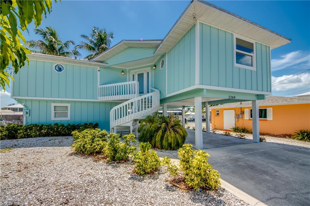 Experience the ultimate Southwest Florida waterfront lifestyle in this beautifully updated stilt home located in the charming fishing community of Saint James City. A stunning curved staircase creates a grand first impression, leading to a residence thoughtfully renovated with today's most sought-after features.

Designed for both elegance and durability, the home boasts a metal roof, impact-resistant windows and doors, updated flooring throughout, and a beautifully remodeled kitchen featuring granite countertops, custom cabinetry, and new stainless-steel appliances. The bright, open living spaces are filled with natural light and perfectly positioned to capture coastal breezes and waterfront views.

Step outside and discover what truly sets this property apart. Situated on a navigable canal with quick access to open water, the property includes a 7,000-pound boat lift, making it effortless to launch your next fishing adventure or sunset cruise. Anglers will appreciate having some of the finest fishing in Southwest Florida right at their doorstep, with easy access to Pine Island Sound, San Carlos Bay, and Gulf waters.

The lower level offers a spacious storage room, providing ample space for fishing gear, boating equipment, kayaks, tools, and all your waterfront toys. After a day on the water, unwind in the covered patio area, the perfect setting for grilling fresh-caught seafood, entertaining friends, or enjoying casual outdoor dining while taking in the tropical surroundings.

Just a short boat ride away, you'll find the pristine beaches and natural beauty of Cayo Costa State Park, famous for shelling, boating, fishing, and untouched Gulf-front shoreline.