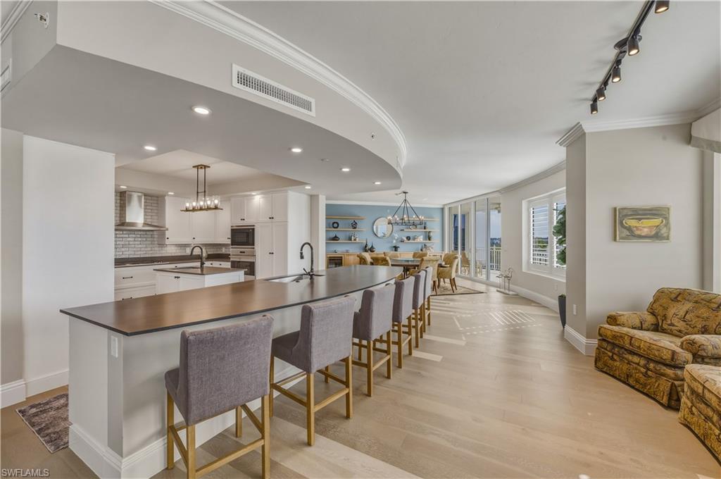 Exceptional end-unit residence in the newer tower at Aqua at Pelican Isle, ideally positioned with southwest exposure and beautiful views of the marina, and inland waterways out front, plus golf course views to the rear. With a wall of windows and doors natural light is in abundance.   Two separate lanais with sliding doors, allows this residence to capture both sunrise and sunsets along with refreshing coastal breezes. One of only a few with built in grille on the lanai.

The spacious floorplan offers 3 bedrooms plus a large den and features two distinct living areas, creating flexibility for entertaining and comfortable everyday living. Natural light pours in from the additional side windows unique to an end residence, enhancing the open feel throughout.

The gourmet kitchen is thoughtfully appointed with a natural gas cooktop, built-in ice machine, oversized island, and generous cabinetry—ideal for both casual dining and hosting. The primary suite is a private retreat with an exceptionally large spa-style bath and expansive closets. Guest bedrooms provide comfort and privacy for family and visitors.

Aqua is a boutique luxury building with only 32 residences in the second tower and an unmatched amenity package designed to elevate your lifestyle. Enjoy direct Gulf access through Wiggins Pass from the private marina, a state-of-the-art fitness center, spa, resort-style waterfront pool, theater, game room, sky lounge, and sunset terrace. Additional highlights include a golf simulator, putting green, dog park, multiple guest suites,  concierge services and 24/7 security.