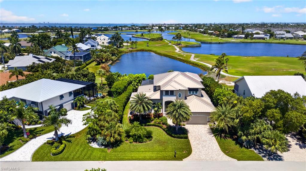 Welcome to 9066 Mockingbird Drive, where exceptional craftsmanship, coastal elegance, and the beauty of island living come together in The Dunes on Sanibel Island. Custom built in 2018 and overlooking the 7th hole of The Dunes Golf & Tennis Club, this stunning 3-bedroom plus office, 4-bath residence offers an inviting combination of luxury, comfort, and breathtaking golf course and water views.
Step inside to a spectacular living room with soaring 20-foot ceilings, expansive windows, and sliding glass doors that fill the home with natural light while bringing the beauty of the outdoors inside. An open, airy design, beautiful flooring, and coastal-inspired finishes create a welcoming atmosphere, while the spacious dining area provides the perfect setting for entertaining family and friends.
The beautifully appointed kitchen features crisp white cabinetry, quartz countertops, a coastal-inspired tile backsplash, stainless steel appliances, and generous storage, blending timeless style with everyday functionality. Thoughtful details throughout the home include solid-core interior doors, insulated interior walls, and high ceilings that enhance the sense of space and privacy.
Each of the three bedrooms enjoys its own private en-suite bath, offering a comfortable retreat for family and guests. A dedicated office provides additional flexibility for working from home or creating a space to suit your island lifestyle.
Outdoor living is equally impressive. The expansive screened lanai features a resort-style pool and spa, outdoor kitchen, and elegant travertine decking, creating your own private tropical retreat. Whether enjoying morning coffee overlooking the tranquil pond, relaxing poolside, or entertaining beneath the Florida sunshine, the picturesque golf course and water views provide an unforgettable backdrop.
Built with quality and peace of mind in mind, the residence features concrete block construction on the first level, a standing seam metal roof, impact-resistant windows and doors, storm shutters protecting the lanai, and a whole-house generator.
Offered partially furnished, this exceptional home combines modern construction, sophisticated coastal design, and an outstanding location within The Dunes. With championship golf, island beaches, and the natural beauty of Sanibel nearby, 9066 Mockingbird Drive invites you to experience the very best of island living.