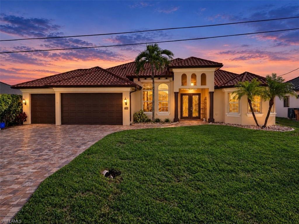 NO FLOOD ZONE! ALL ASSESSMENTS PAID IN FULL! Discover the beauty of Cape Coral waterfront living in this inviting home featuring breathtaking intersecting canal views from the living area, kitchen, and primary bedroom. Offering three bedrooms plus a den and a spacious three car garage, this home provides room to relax, work, and entertain. The southern exposure provides beautiful natural light and spectacular Southwest Florida sunsets right from your own backyard. The picture frame screened lanai showcases the expansive water views and creates the perfect setting for enjoying the Florida lifestyle. Hurricane protection includes electric roll down shutters at the front and rear of the home and manual shutters on the sides. A GenerLink system installed by LCEC provides a generator ready connection. Additional home highlights include a newer metal barrel tile roof with a warranty, a brand new water heater, plantation shutters, and a new pool filter. Conveniently located within walking distance of nearby schools, this home also offers the opportunity to enjoy Southwest Florida by boat, with nearby marinas, waterfront restaurants, and destinations such as Cape Harbour and Rumrunners just a ride away. Experience Southwest Florida living at its finest, where breathtaking intersecting canal views, spectacular sunsets, and the boating lifestyle come together to create a place you will love to call home. Some Photos are virtually staged.