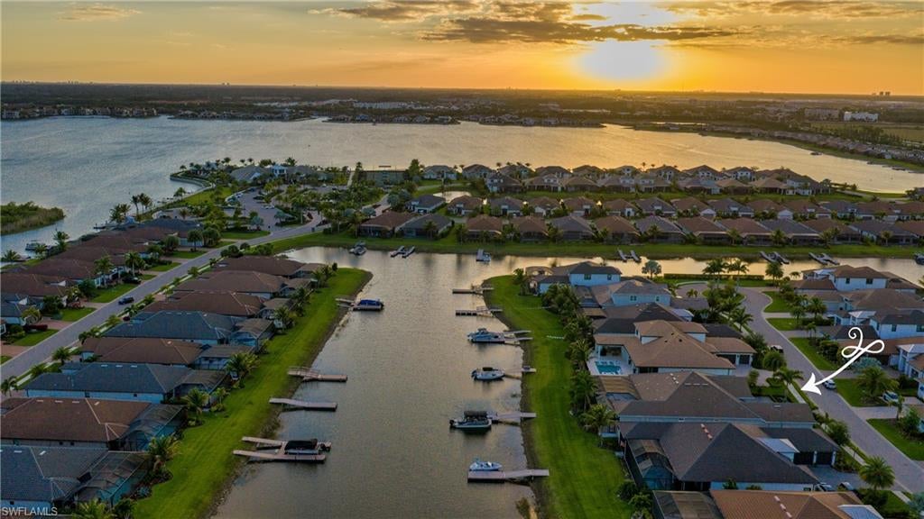 Exceptional waterfront living in Sold-Out Esplanade Lake Club! This southern facing designer residence is situated on an estate homesite with private boat dock! Every detail of this highly sought-after single-story Beacon floorplan has been thoughtfully selected for luxury and livability. Spanning over 3,300 air-conditioned square feet including 3 en suite bedrooms plus a dedicated home office, air-conditioned 3-car garage and expansive lanai. The striking timeless interiors of this great room design include carefully curated, designer lighting, thoughtful architectural ceiling details, 8.75” baseboards, 12-foot ceilings, crown molding, window treatments, motorized shades, a new custom iron cantilever front door, custom interior doors, new wide-plank flooring, and distinctive tile work throughout. The primary bedroom is adjacent to the dedicated home office. This private sanctuary offers spacious customized his and her walk-in closets, a spa-like bathroom with dual sinks, large walk-in shower and separate water closet. Two additional guest suites feature walk-in closets and en suite baths. The great room with natural gas fireplace flows to the chef's kitchen with professional grade natural gas cooktop, dual ovens, built-in refrigerator, custom walk-in pantry and large center island and eat-in dining area overlooking the lake. The design provides a seamless indoor-outdoor flow for perfect Florida living. The incredible outdoor living complemented by stunning lake views nearly doubles the living space for entertaining and family enjoyment. Take a sunset cruise from your back yard dock and return to the ambiance of the linear fire feature adjacent to the outdoor living room or gather for a poolside dinner in the gracious outdoor kitchen and dining area. The custom pool features a sun-shelf, spa, water features and an expanded concrete set natural stone pool deck. A boater's paradise, the property includes a deeded dock with electric and water, whole house generator, motorized roll-down hurricane screens and privacy screens, tankless hot water heater and whole house Kinetico soft water system with kitchen reverse osmosis. The beautifully curated furniture package featuring primarily Restoration Hardware pieces is available for separate purchase. Designed to reflect modern elegance and timeless style, the collection includes high-end materials, statement pieces, and a cohesive aesthetic throughout. Each space has been thoughtfully styled to create a polished, move-in-ready home. A rare opportunity to enjoy a designer-furnished residence without the time or expense of sourcing premium furnishings. Globally sourced artwork adds a distinctive, curated touch throughout the home. Welcome to your Florida Oasis!