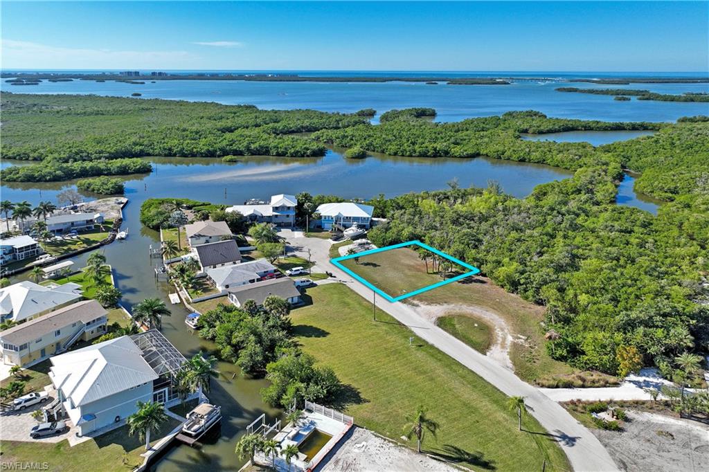 Exceptional waterfront homesite in a premier Estero location, perfectly suited for a custom coastal residence. Positioned on Sailfish Street, the property backs to protected mangroves and open water, creating a naturally private and tranquil setting ideal for a thoughtfully designed new build. This is a rare opportunity to create a custom home that captures serene water views while enjoying unmatched convenience. Located directly across the street from Coconut Point, future owners can walk to shopping, dining, and entertainment while returning home to a quiet, nature-framed waterfront retreat. The mangrove backdrop offers both environmental protection and a picturesque natural buffer, making it an ideal canvas for a modern Florida design that embraces indoor-outdoor living, elevated outdoor spaces, and water-oriented architecture. With close proximity to Gulf beaches, RSW International Airport, and major thoroughfares, this location supports both full-time living and seasonal enjoyment. Whether envisioning a contemporary coastal build or a timeless Florida retreat, this homesite delivers the setting, privacy, and location to bring that vision to life. Conceptual floor plans shown reflect custom home designs by Kaye Lifestyle Homes, the only family-owned home builder voted Builder of the Year for the State of Florida by the Florida Home Builder's Association.