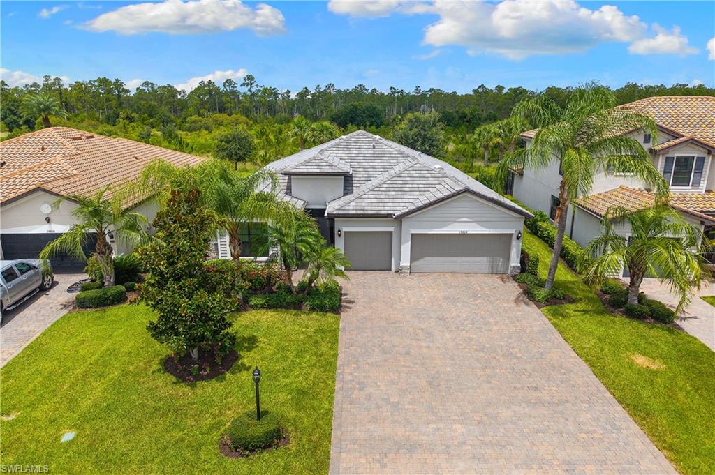 ENJOY SPECTACULAR SUNSETS FROM THIS ULTRA-PRIVATE "SUMMERVILLE" POOL & SPA HOME WITH PRESERVE VIEWS AND FENCED-IN BACKYARD IN THE PLACE AT CORKSCREW! This 2018 residence offers 3 Bedrooms + Den, 3 FULL BATHS (1 Guest Bath is En-Suite), 3 Car Garage, 2,445sf living area. The western rear exposure provides BREATHTAKING SUNSETS to enjoy each evening from the covered lanai while taking in the PEACEFUL WOODED VIEWS. Relax on your covered, screened lanai featuring OUTDOOR KITCHEN with GRANITE TOP/BACKSPLASH and STACKED STONE FACE with stainless steel grill, beverage refrigerator, trash pullout and storage. The Lanai overlooks your HEATED POOL AND SPA and PRIVATE PRESERVE landscape with no neighbors behind you. Beyond the pool cage, the FENCED-IN BACKYARD provides pets and kids room to play. This home has easy upkeep with LARGE TILE throughout, (NO CARPET ANYWHERE)! A DOUBLE DOOR SCREENED FRONT ENTRY welcomes you home and leads to the GLASS DOUBLE DOOR ENTRY, filling the home with natural light. As you enter, take notice of the CROWN MOLDING in the main areas and a CUSTOM MIRROR FEATURE WALL positioned across from the Den with double door entry. This OPEN CONCEPT HOME showcases RICH BROWN CABINETRY, a MASSIVE ISLAND with PROFESSIONALLY SEALED GRANITE countertops, CUSTOM WALK-IN PANTRY with BUILT-IN SHELVING, STAINLESS STEEL APPLIANCE PACKAGE and abundant storage. The Kitchen is joined by the Dining Area and Greatroom creating open sight lines, which is perfect for enhanced conversation while entertaining guests. The Greatroom showcases a TRAY CEILING, additional RECESSED CAN CEILING LIGHTING, SURROUND SOUND SPEAKERS and gorgeous views of your outdoor living space. The Primary Bedroom is enhanced by a TRAY CEILING, views of your pool and preserve, and DUAL CLOSETS with CUSTOM CLOSET ORGANIZERS. The Primary Bath offers a SEPARATE SOAKING TUB AND SHOWER WITH HEAVY GLASS ENCLOSURE, split vanities with granite countertops and private water closet. Your guests will feel right at home with two secluded guest bedrooms with either a private EN-SUITE BATH experience or convenient hall bath, all featuring HEAVY GLASS ENCLOSURES. The Laundry Room features BUILT-IN CABINETRY and LAUNDRY SINK. This home features a split AC SYSTEM with thermostats in each bedroom. The garage boasts WHOLE HOME SURGE PROTECTION, electrical configurations for a portable generator and EV charger, garage refrigerators and added insulation. Pool control panel was replaced in 2025. The amenities at The Place at Corkscrew are second to none!... Resort Pool w/100' Waterslide & Spa, Indoor Restaurant and Bourbon Bar, Cafe, Outdoor Bar, Fitness Center, Movement Studio, Tennis, Pickleball, Bocce, Basketball, Playground, Dog Park, Childwatch, Spa Services, 2 Entry Gates. Just Minutes to Schools, Shopping, Restaurants, Airport, Beaches. PUBLIX GROCERY STORE PLAZA, JUST 1.4 MILES AWAY! OTHER TENANTS INCLUDE DUNKIN DONUTS, UPS STORE, LEGNO ITALIAN RESTAURANT, NAIL SALON, DENTAL OFFICE, AND MORE!
