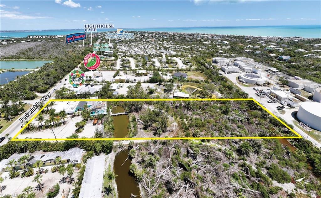 This bank-owned property presents an iconic Sanibel development opportunity offering 200 feet of frontage on Periwinkle Way, 2.5-plus acres of land and waterfront features. Presenting a once-in-a-generation opportunity to acquire one of Sanibel Island’s most storied and strategically located commercial parcels. Formerly home to the iconic Jacaranda Restaurant and Bar, a beloved institution that served generations of islanders and visitors, and most recently the Tipsy Turtle, this legacy property is ready for its next chapter. Ideally along 200 feet of frontage on Periwinkle Way, Sanibel’s main thoroughfare and commercial spine, the property spans over 2.5 acres of developable land zoned General Commercial and D2 Upland Wetland. This premier site offers exceptional development flexibility, with initial assessments suggesting the potential to construct 8-9 residential units. Alternatively, zoning allows for a mixed-use development, combining residential living with a commercial component. The final residential count in this scenario would vary depending on footprint of the commercial structure, allowing for a custom-tailored approach to suit investor or developer goals. Adding to its appeal, the property features a scenic central lake and frontage along the tranquil Sanibel River at the rear—rare natural amenities that enhance its desirability for residential or hospitality development. Whether reimagined as an upscale enclave, a vibrant mixed-use destination or a new community hub, this property represents a unique and irreplaceable opportunity in the heart of Sanibel Island. Iconic history. Prime location. Boundless potential.