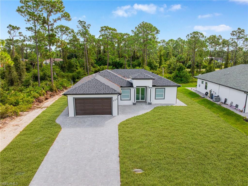 Welcome to this stunning modern home where elegance and comfort come together perfectly. This brand new construction features three spacious bedrooms, plus den, and two luxurious bathrooms, each designed with high end finishes and custom tile work that give the home a true upscale feel. Step inside and you’ll immediately notice the open modern layout, filled with natural light and perfect for both relaxing and entertaining. The kitchen is the centerpiece of the home, featuring top of the line wood cabinetry, beautiful countertops, and premium fixtures ideal for anyone who loves to cook or host. The seamless flow between the kitchen, dining, and living spaces gives this home an inviting contemporary feel. The flooring throughout has a rich polished finish that enhances the home’s warmth and sophistication. One of the standout features of this property is the full paver installation surrounding the entire exterior, a detail rarely included by builders. It adds a touch of class while also providing easy maintenance and durability for years to come. Located in a peaceful and growing area of Lehigh Acres, this home offers the perfect balance of privacy and convenience. For added privacy, enjoy your fenced in back yard. You’re just minutes away from shopping centers, restaurants, schools, hospitals, and main highways, giving you quick access to everything you need while keeping a calm residential atmosphere.
