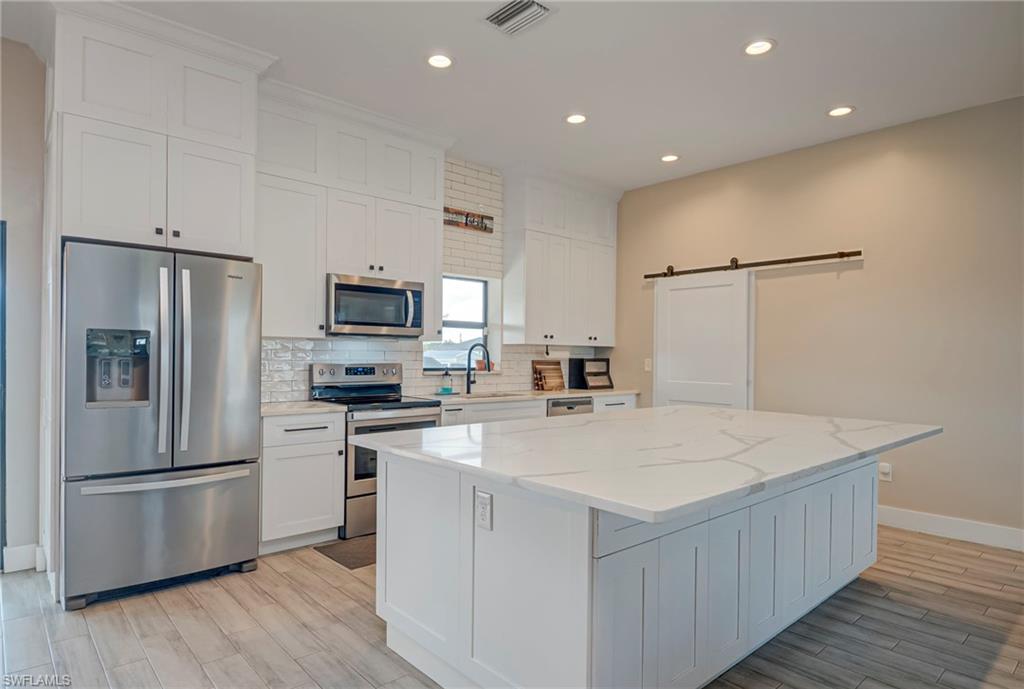 Move-in ready and built in 2019, this beautiful 4-bedroom, 2-bathroom home sits on 1.25 fully fenced acres in a peaceful area of LaBelle, offering the perfect blend of modern construction, country charm, and room to live the lifestyle you've been dreaming of. Bring your boats, RVs, chickens, and all your hobbies—there's no HOA! The spacious open floor plan is ideal for both everyday living and entertaining, while the kitchen is the heart of the home, featuring an oversized island that's perfect for entertaining, abundant counter space, and two charming barn doors that add warmth and character. Ceramic wood-plank tile flooring flows throughout the home, providing both style and durability. The private primary suite offers a walk-in shower and a dual-sink vanity, creating a comfortable retreat at the end of the day. Outside, you'll appreciate everything this property has to offer, including a 1-car attached garage, an impressive 30x40 oversized detached garage with plenty of room for vehicles, equipment, or a workshop, plus a 30x30 carport with an RV hookup, making it easy to accommodate your recreational vehicles or visiting guests. A yard irrigation system helps keep the property looking its best.
With a roof and A/C that are only six years old, this well-maintained home is truly move-in ready. Whether you're looking for space to spread out, store your toys, start a hobby farm, or simply enjoy peaceful country living, this exceptional property checks all the boxes.