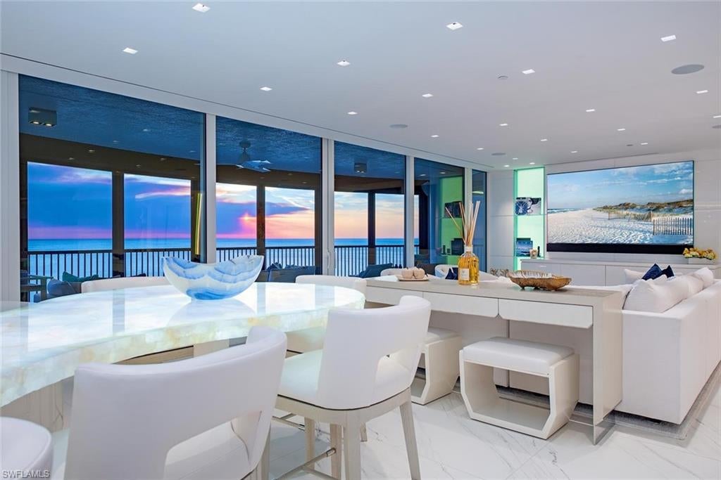 Showcasing an extraordinary blend of sophistication and coastal prestige, this remarkable beachfront residence within The Remington represents the pinnacle of Bay Colony luxury living. Following an impressive multi-million-dollar tower renovation, this iconic address delivers a refined Gulf-front lifestyle with privileged proximity to the Ritz-Carlton and exclusive access to the private Bay Colony Beach Club. Perfectly designed to capture both sunrise and sunset vistas, this rare east-to-west residence features dual terraces that frame sweeping water and city views while welcoming natural light throughout the day. The spacious floor plan offers two luxurious bedroom suites, a versatile den easily suited as a third bedroom, and three beautifully appointed baths. A private elevator whisks you from the secure under-building garage—with two dedicated parking spaces—directly into your private foyer, offering the elevated arrival experience expected of a residence of this caliber. The interiors have been extensively reimagined with exceptional craftsmanship and the finest designer finishes. A stunning chef’s kitchen showcases premium Wolf and Sub-Zero appliances, custom cabinetry, and a dramatic island crafted from rare semi-precious exotic stone, creating a true statement centerpiece. Smart home integration through a Savant automation system provides effortless control of lighting, climate, and entertainment. Wine enthusiasts will appreciate the custom climate-controlled wine display secured by a sleek touch-access glass entry, while bespoke closet systems and finely crafted millwork further reflect the meticulous attention to detail carried throughout the home. The Remington offers a level of service and amenity rarely found, including a 24-hour staffed lobby, on-site management, elegant social salons, club and card rooms, library, state-of-the-art fitness facilities, luxurious guest suites, and a resort-inspired pool and spa accented by a fireside gathering area. Ownership also conveys the incomparable privileges of Bay Colony and Pelican Bay, including access to miles of pristine white sand beaches, private beachfront dining clubs, attended beach services, championship tennis programs, cutting-edge fitness centers, educational and cultural programs, and an extensive network of scenic walking, biking, and kayaking trails. This is a rare opportunity to own a masterfully renovated Gulf-front residence where exceptional design, world-class amenities, and one of Naples’ most prestigious addresses come together to create a truly elevated coastal lifestyle.
