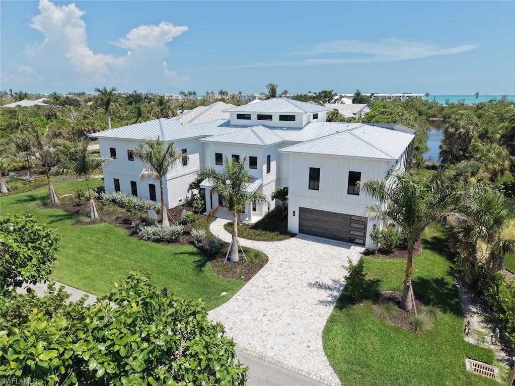 New Construction on Sanibel Island - Step into coastal luxury with this exceptional estate offering deeded beach access and over 11,000 square feet of total space (4400 under air). Built with solid concrete and ICF (Insulated Concrete Form) construction, this home delivers superior storm resistance, energy efficiency, and peace of mind—without compromising elegance. Designed for both refined living and effortless entertaining, every detail reflects timeless craftsmanship and modern sophistication. At the heart of the home is a designer chef’s kitchen outfitted with premium Wolf and Sub-Zero appliances, complemented by a built-in Miele coffee station, 60" dual fuel Wolf range, Wolf steam convection oven and speed oven, 36" Sub-Zero refrigerator and 36" freezer and 30" wine cooler. Custom Wood-Mode inset cabinetry pairs beautifully with Cambria and Pompeii Quartz countertops, creating a space that is as functional as it is stunning. Retreat to the expansive primary suite, where long lake views provide a serene coastal backdrop. The spa-inspired bath elevates relaxation with a luxurious wet room, soaking tub, and private steam room with shower—your personal sanctuary after a day at the beach. Indoor living flows seamlessly to your private outdoor oasis, featuring a heated sparkling pool with sun shelf, spa, and a fully screened patio and pool enclosure—perfect for year-round enjoyment. This home is finished to the highest standards, including engineered hardwood floors, level-five drywall finish, 8-foot solid core doors, crown molding throughout, and thoughtfully designed built-in closets. Kohler and Hansgrohe fixtures, along with LED lighting throughout, enhance both style and efficiency. Additional highlights include a spectacular shell stone travertine entry, huge primary closet, four spacious garage bays and 4.5 beautifully appointed bathrooms, ensuring comfort and convenience for family and guests alike, with tankless gas water heaters and 1000 gallon LP tank. A rare opportunity to own a meticulously crafted coastal residence where luxury, durability, and beachside living come together effortlessly.