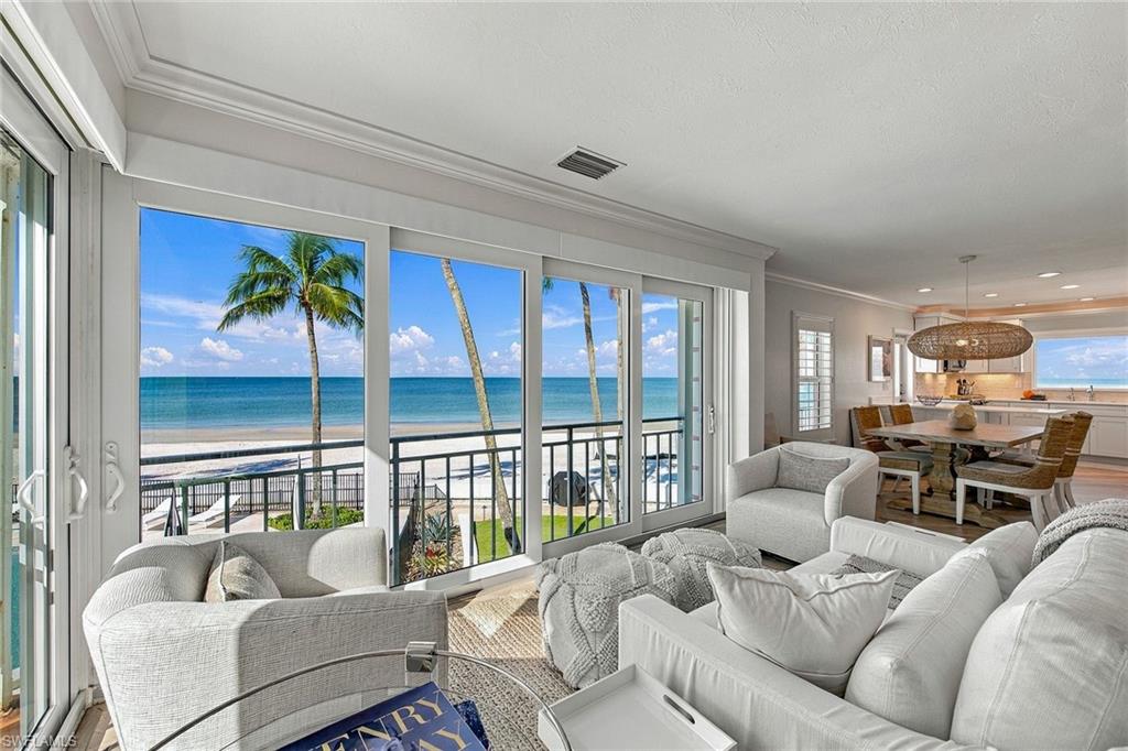 A rare opportunity to experience coastal living directly on the sand, this beautiful beachfront villa at The Shores of Naples offers an intimate connection to the Gulf, with sweeping views of turquoise waters, white sand beaches and Naples' celebrated sunsets. With just 32 residences in this boutique beachfront enclave, opportunities to own a front-row coastal retreat of this caliber are seldom available. Thoughtfully reimagined with a refined coastal aesthetic, this two-bedroom, two-bath residence showcases light-filled living spaces, with expansive impact-resistant windows and doors framing the Gulf as a captivating backdrop. White oak flooring brings warmth and continuity to the open living areas, which are positioned to maximize the remarkable beachfront setting. The beautifully appointed kitchen combines timeless finishes with modern functionality, featuring a picture window overlooking the Gulf, a glass-front Sub-Zero refrigerator and an inviting breakfast bar. A dedicated bar area with wine refrigerator provides an additional touch of convenience for entertaining. Both spacious bedrooms offer ample storage with spacious closets and newly built-in wardrobes, while two tastefully updated baths complement the residence's understated coastal elegance. Additional conveniences include in-residence laundry and a curated collection of coastal furnishings. Perhaps the most compelling feature is the residence's private rear door and stairway, providing direct access to the beach. Whether enjoying morning visits along the shoreline, afternoons beside the Gulf or sunsets over the water, the experience is distinctly connected to its beachfront surroundings. Positioned toward the end of Gulf Shore Boulevard North, The Shores of Naples offers an intimate residential setting complemented by a beachfront swimming pool, lush manicured grounds, and a grilling area overlooking the sand and Gulf waters. This seldom-available residence presents a distinctive opportunity to own directly on one of Naples celebrated stretches of shoreline.