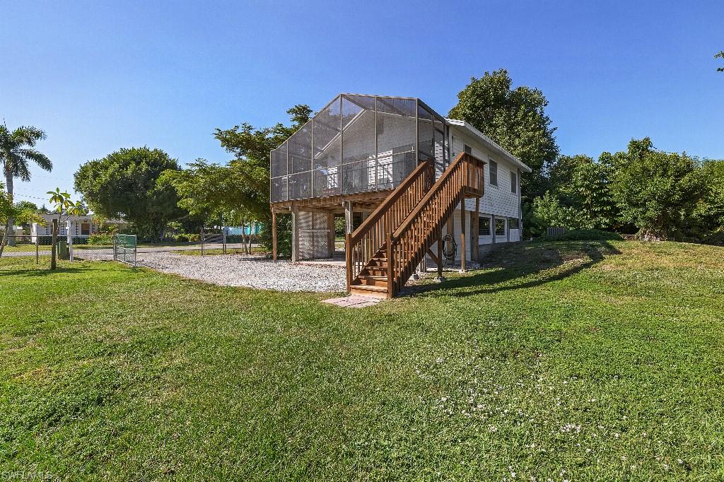 Back on the market at 'no fault of Seller' -- Buyer's financing fell through. Experience the quintessential Pine Island lifestyle in this beautifully appointed retreat, where tropical serenity & phenomenal flora & fauna meets modern accessibility. This charming island home is ideally positioned moments from local marinas, dining, shopping, and the island's iconic scenic bike path. The upper level radiates warmth, featuring a sun-drenched living area and two comfortable bedrooms. The kitchen serves as a focal point, elevated by exquisite Portuguese porcelain tile countertops and a matching backsplash. For relaxation, the screened lanai offers a seamless transition to the outdoors to unwind, overlooking peaceful views of lush surroundings; perfect for enjoying your morning coffee or evening cocktails. The lower level provides exceptional flexibility with a private-entrance guest suite, including a third bedroom, half bath, and expansive storage—an ideal setup for an art studio or workshop. With a new roof and water heater (2023), a fully fenced yard, and verdant mature landscaping & fruit trees on two lots, this home is a turnkey slice of paradise. Don’t wait---paradise is calling!!