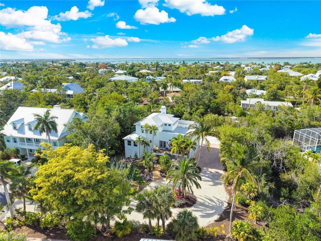 Occupying the largest homesite within Sanibel's exclusive gated enclave of Kinzie Island, this exceptional waterfront residence offers an extraordinary blend of boating, beach access, and privacy. Set on more than half an acre, the property enjoys a coveted canal-front setting with direct navigable Gulf access and ample room to create a private outdoor retreat, including a potential resort-style pool.

Just steps away, a private boardwalk leads directly to Sanibel's world-renowned shell-strewn beaches, while the community pool, tennis, pickleball, and bocce courts are conveniently nearby.

Designed for both relaxed coastal living and effortless entertaining, the home is filled with natural light and timeless island charm. The chef's kitchen serves as the heart of the residence, featuring premium appliances, a gas range, wine cooler, expansive island seating, and seamless flow into the dining and living areas. A spectacular screened lanai, highlighted by a stunning cypress tongue-and-groove ceiling, overlooks the tranquil canal and provides the perfect setting for morning coffee, sunset cocktails, and year-round outdoor enjoyment.

Offering three bedrooms, including two private primary suites, the home provides exceptional comfort and flexibility. One primary suite occupies the entire third floor, creating a secluded retreat with elevated views and added privacy. An expansive lower-level bonus area provides extra space that will delight.  A spacious rooftop sundeck with glimpses of the Gulf showcase refreshing island breezes, spectacular sunsets, and expansive tropical skies.

Outside, a private dock and boat lift provide access to Sanibel's pristine waterways, inviting boating, fishing, kayaking, paddleboarding, and Gulf adventures right from your backyard. A spacious three-car garage offers abundant room for vehicles, beach gear, bicycles, and recreational equipment.

With just 22 residences, Kinzie Island remains one of Sanibel's most sought-after waterfront communities. Community pool, tennis, bocce, a beach boardwalk & more amenities give active residents plenty to choose from.  Ideally located on the island's east end for convenient on-and-off access, this remarkable property combines direct Gulf boating access, beachside convenience, exceptional privacy, and one of the most significant homesites in the neighborhood, creating a truly rare island offering.