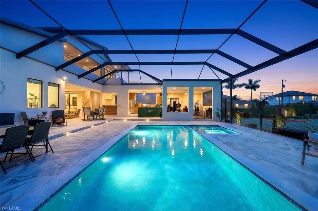 Rare combination of space, privacy, sports, and contemporary home. Featuring 4 bedrooms, 4 full baths, and 3,258 SF of living space on an extraordinary 0.51-acre lot. With parking for up to 9 vehicles behind a private automatic gate, a basketball & pickleball court, an outdoor gym, a 2nd-floor open-air game room and balcony, and a resort-caliber pool and outdoor kitchen, this is a property built for the family that refuses to compromise on space, quality, or lifestyle! Custom-built front entry doors, a metal roof at a 20% pitch, solid concrete block construction engineered with the structural capacity to add a second story, hurricane impact windows and doors throughout, and a completely gated and private perimeter create a home that is as much a fortress as it is a family retreat. Soaring cathedral and vaulted ceilings that open up the space, with views to the pool, gazebo, and private backyard setting that make the home feel connected to the outdoors at every turn. The entertainer's kitchen is anchored by a massive center island with marble waterfall edges, bar top seating, a sleek modern appliance package, and a walk-in pantry. A full formal dining space and casual bar-top seating. The primary suite is exceptional in every respect. Five windows flood the room with light, the spa-inspired bathroom features an oversized walk-in shower with multiple heads, and the California Closet built-in system is the kind of walk-in closet that buyers talk about long after the showing. The junior master suite functions equally well as an in-law suite or private guest quarters. Every bedroom is generously sized with its own full ensuite bath, walk-in closet with built-in system, and custom desk — accommodating families, guests, and work-from-home needs simultaneously without anyone feeling cramped. The private backyard is a world of its own! The oversized custom saltwater pool with a large sun shelf! Solid concrete subfloor, surrounded by an expansive paver deck, mature palms, lush fruit trees, and a gazebo. The outdoor kitchen is as large and well-equipped as most indoor kitchens — featuring a full-size refrigerator, grill, smoker, marble countertops, a vented hood, a side burner, and bar-top seating that can accommodate a crowd. A covered open-air room currently used as a private gym, a second-floor open-air game room and balcony, and the pickleball/basketball court complete an outdoor living package! The automatic gate and driveway provide secure parking for up to 9+ vehicles. Ideal for large families, car enthusiasts, business owners, or storing a boat or trailer behind a private & secure perimeter. The Seven Islands Project: Marriott-branded hotel, waterfront restaurants, a tiki bar, a public marina, a lagoon resort beach, condominiums, an outdoor amphitheater, a splash pad, a kayak launch, a dog park, and a food truck park. Cape Coral Grove: national grocer, major retailers, boutique shops, hotel, 4 public parks, farmers markets, and destination dining.