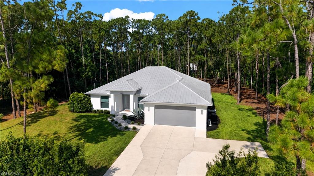 Welcome to San Carlos Estates, where unmatched freedom, luxury, and convenience all come together in the heart of Bonita Springs. This newer estate home boasts three bedrooms, two and a half bathrooms, a study, and a bonus room. Set on a rare NO-HOA, 1.25-acre homesite offering 100% uplands of useable land, privacy and utility become truly unmatched for you to build your dream oasis. Inside you will be met with natural light that sores throughout the main living thanks to the 16-foot wide, fully-pocketing sliding glass doors that effortlessly blend the outside and indoor living areas; and double-tray ceilings. The spacious chef’s kitchen is an entertainer’s dream, equipped with smart stainless-steel appliances, oversized quartz island with seating for up to six, an induction cooktop, and custom cabinetry from floor to ceiling for luxurious and thoughtful storage. The owner’s suite offers his and hers custom built-in closets, walk-in shower, custom floating cabinetry, and LED frameless mirrors. Direct access to the outdoor living area, completes this private sanctuary. The outdoor living area steals the spotlight showcasing 417 square feet of screened-in lanai space and breathtaking Western exposure views spanning over 190ft long and 160ft wide. Fitted with three outdoor ceiling fans and an air-conditioned half-bathroom (pool bath) this space is ideal for entertaining or relaxing year-round. Additional highlights include solid-wood custom interior 8ft doors, PGT hurricane-rated impact windows and doors, whole-home Generac generator, air-conditioned two-car garage with epoxy floor coating, insulated garage door, laundry room with storage, electronic roll down shades, extended concrete driveway, all protected by a metal roof. Fresh landscaping and irrigation zones were just installed for extended outdoor enjoyment and privacy around the perimeter. Located outside of a designated flood zone, the home offers added peace of mind. Situated on one of San Carlos Estates’ most desirable streets, this home offers privacy and serenity with convenient access to Old 41, US-41, beaches, dining, shoppes and everything Bonita Springs & Southwest Florida has to offer. This home and location are truly spectacular with homesites like this selling for 450k or more – this home is a must see.