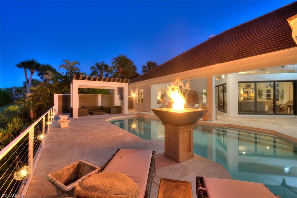 Positioned within the prestigious Sanctuary at Wulfert Point, this exceptional three-bedroom, four-bath residence embodies the timeless sophistication of British West Indies architecture paired with modern luxury and effortless indoor-outdoor living. Meticulously updated, the home offers an exquisite blend of craftsmanship, comfort, and resort-inspired amenities in one of Sanibel Island's most coveted golf course communities.  A lush tropical approach sets the tone, with climbing bougainvillea and jasmine cascading across the home's exterior, creating a welcoming sense of arrival. Inside, rich dark wood flooring, soaring ceilings, custom millwork, and refined finishes define the elegant interior spaces. The well designed split floor plan affords privacy for family and guests while maintaining flow for entertaining. The features a stunning gourmet kitchen, beautifully appointed with custom cabinetry, luxury finishes, abundant workspace, and exceptional storage. Seamlessly connected to the dining and great room, it creates the perfect setting for both intimate gatherings and large-scale entertaining. A richly appointed office provides an inspiring retreat for work or reflection. With its handsome finishes and sophisticated ambiance, it feels worthy of Hemingway himself. Dramatic floor-to-ceiling sliding glass doors open to a covered lanai complete with outdoor kitchen and multiple lounging & dining areas. Beyond lies a spectacular custom pool area with a striking pergola where a gentle waterfall cascades from the roofline into the pool below, a designer pedestal fire bowl, sun decks, and lush tropical surroundings. The expansive primary suite offers the feel of a boutique resort, featuring a generously sized walk-in dressing room that buffers the sleeping quarters from an amazing spa bath appointed with dual vanities, a sculptural freestanding soaking tub, and an oversized walk-in shower designed for daily rejuvenation. Two additional guest suites each offer comfort and privacy with their own full baths. A fourth full bath doubles as a pool bath and features a unique shower-to-sauna conversion, adding yet another layer of resort-style indulgence. Surrounding the outdoor living spaces, tropical landscaping creates a park-like setting and natural privacy buffer from the golf course beyond, allowing residents to enjoy tranquil views of swaying palms & beautifully landscaped grounds. Additional features include a spacious garage accommodating two vehicles plus a golf cart. The Sanctuary at Wulfert Point is renowned for its championship golf course, incredible clubhouse & restaurant, attended fitness center, other amenities, and unmatched natural surroundings. Membership in this private equity club is optional.  Moments from Sanibel's world-famous beaches, wildlife preserves, and boating opportunities, this remarkable residence presents a rare opportunity to enjoy refined island living in one of SW Florida's most distinguished communities.