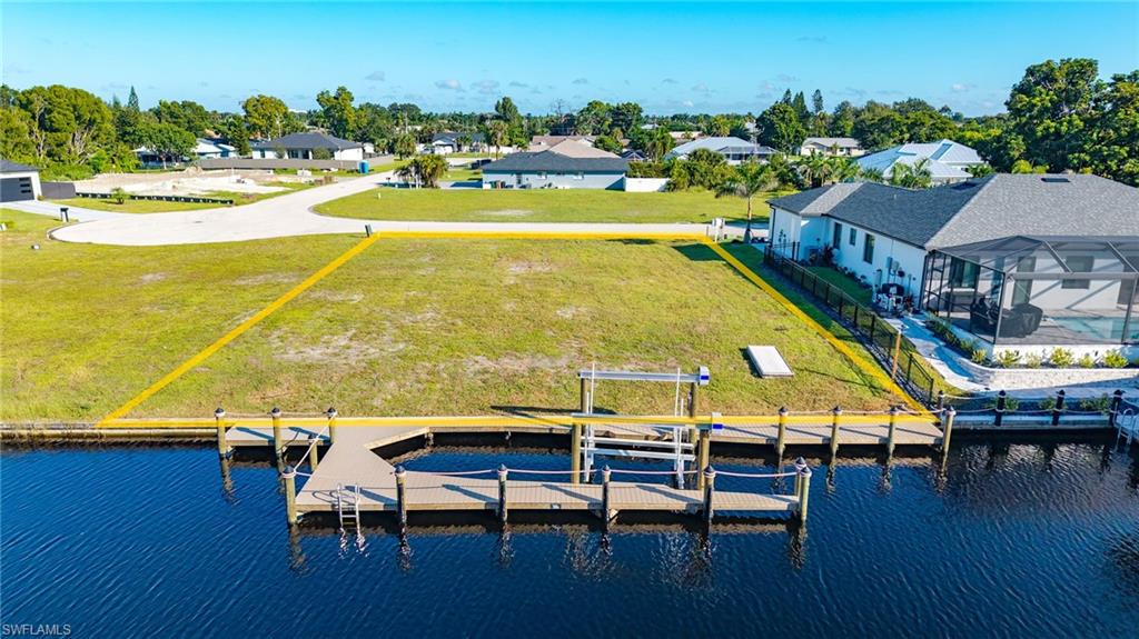 Direct sailboat access to the Gulf of Mexico - with less than a 10-minute boat ride to the Caloosahatchee River, and no bridges between your dock and the river - 1906 Ottersrest Lane brings your waterfront plans closer to reality. This improved lot offers something especially valuable to a buyer ready to build: much of the work that comes before construction has already been done. More than $100,000 has already been invested in waterfront improvements, paid assessments, utilities, soil testing, and complete house plans approved and permitted by the City of Cape Coral. Choose the approved design and begin with the initial planning and permitting stages behind you, connected water, temporary construction power, and completed soil testing. That means fewer preliminary tasks to coordinate and a shorter path to breaking ground. The approved proposed home offers three bedrooms, three bathrooms, and a dedicated office, with an expansive great room featuring 12-foot ceilings. A spacious kitchen with a large island and butler’s pantry connects everyday comfort with easy entertaining, while a covered lanai and outdoor kitchen make the waterfront setting part of the home’s appeal. A new dock accommodates a boat up to 38 feet and includes a 13,000-pound IMM platform lift, water, power, and a twin-engine Flushmaster system. With this investment already in place and the river just a short ride away, your future home comes with a boating setup to match.