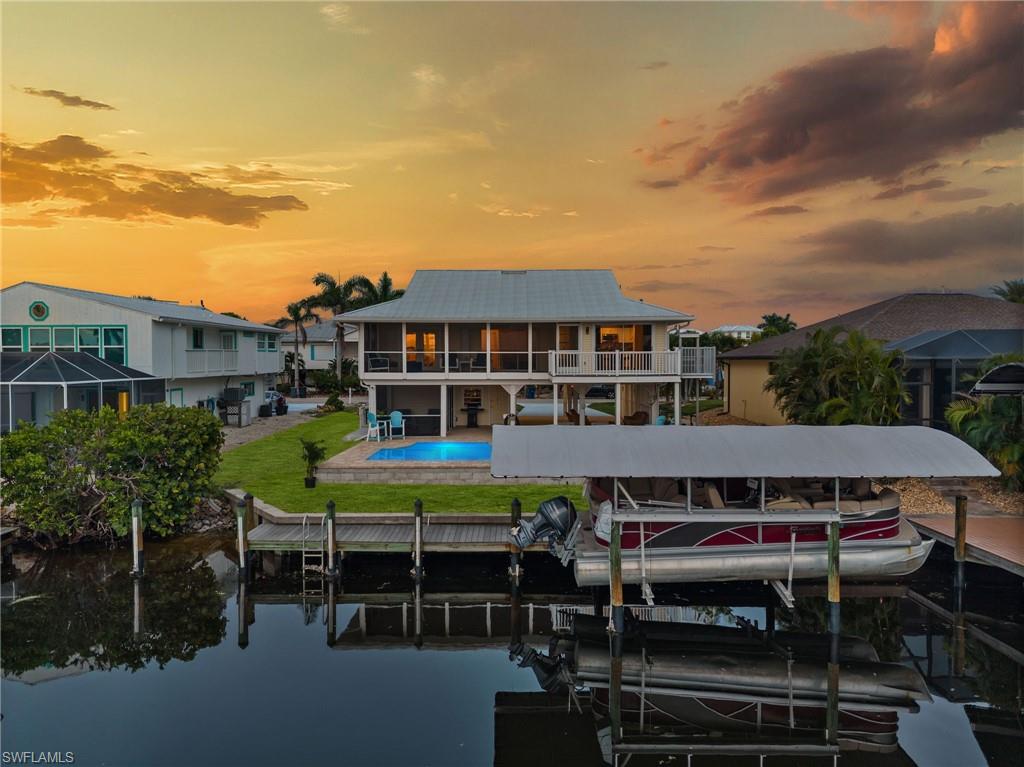 Whimsical Island Living in St. James City! Dive into your own paradise with a brand-new custom pool—complete with a sun shelf, LED bubblers, glow lighting, and a saltwater system. Add direct Gulf access and an 8K boat lift with canopy and composite captain’s walk dock, and adventure by water is just minutes away. From your dock, it’s a quick ride to the open bayfront and the sandy beaches of Sanibel, Captiva, Cayo Costa, and Boca Grande, along with the world-famous fishing grounds of Pine Island Sound. Fresh landscaping enhances the tropical curb appeal, while inside, vaulted ceilings and abundant natural light create an airy, open feeling. Despite its cozy island footprint, each bedroom easily fits a king-size bed, offering a comfortable and well-designed layout. The 2024 remodeled kitchen shines with quartz countertops, white raised-panel cabinets, a center island, and stainless-steel appliances. Sliders from the great room open to a spacious screened lanai, while an open-air balcony off the kitchen is perfect for morning coffee or sunset cocktails. The primary suite is a private retreat with lanai access, two closets (including a walk-in), and a spa-like bath. Guests enjoy their own wing with a pocket slider for added privacy. Nearly every room whispers water views, reminding you that the Gulf is never far. On the lower level, a second screened lanai, shaded gathering space, and two flexible storage rooms offer room to expand—perfect for an outdoor kitchen, game area, workshop, or guest hideaway. There’s also covered parking below with plenty of space for your golf cart—essential for exploring the golf cart–friendly streets of St. James City. With updates including a new roof (2023), Pergo flooring, and reinforced seawall, this home combines peace of mind with the ultimate in waterfront fun. From sun-up to sun-down, this home blends updates, whimsy, and island charm—a tropical retreat made for living.
