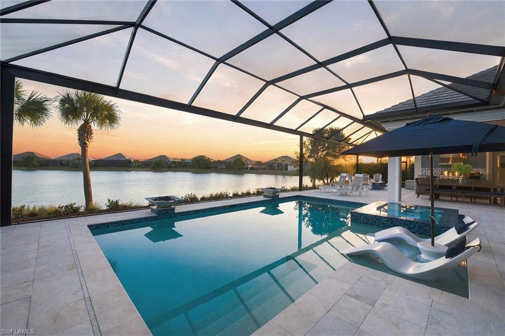 Once-in-a-lifetime opportunity to own a piece of paradise in one of the sought-after coastal communities in the world. Just moments from the world-renowned boutiques, restaurants, and coastal energy of downtown Fifth Avenue, and equally as close to the sugar-white sands of the Gulf, this newer construction, highly coveted Cocoplum custom residence by Stock Luxury Homes is a home designed not simply to be admired but to be experienced. From the moment you arrive a sense of quiet sophistication unfolds. Inside, nearly 3,900 air conditioned square feet of impeccably curated living space is defined by soaring custom coffered ceilings, exceptional craftsmanship, and an effortless connection between indoor elegance and the breathtaking natural beauty beyond. Walls of hurricane-impact glass frame uninterrupted lake views, transforming every room into a living portrait where shimmering water and vibrant sunsets become part of everyday life. Designed for intimate moments and unforgettable gatherings, the residence offers four spacious bedroom ensuites for maximum privacy, a versatile den or executive office/flex space, and five beautifully appointed baths. At its heart, the chef's kitchen is a masterclass in beauty and functionality, featuring gas cooking, bespoke cabinetry and exquisite finishes that inspire everything from quiet morning coffee to elegant dinner parties. Life here extends far beyond your front door. Within The Isles of Collier Preserve, a community inspired by the timeless architecture and enduring character of Old Naples, residents enjoy an exceptional lifestyle immersed in nature. More than half of its 2,400 acres have been preserved as pristine lakes, wildlife habitat and protected natural landscapes. Miles of scenic recreational, biking and kayaking trails wind through the Cypress Waterway, creating an everyday connection to Southwest Florida's remarkable beauty. At the center of the community, The Isles Club offers an amenity experience that rivals a private resort, featuring a state-of-the-art fitness center, large resort and lap pools, numerous tennis and pickleball courts, the Overlook Bar & Grill, multiple kayak launches, and miles of waterways perfect for paddle boarding, kayaking or simply embracing the peaceful rhythm of life on the water. This is more than a newly constructed luxury residence, it is an invitation to embrace one of Naples most desired lifestyles.