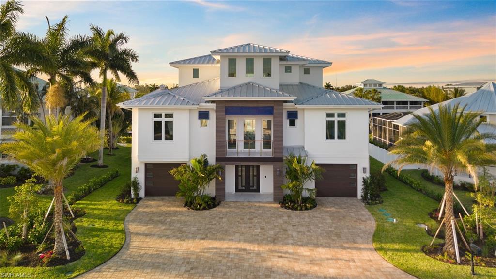 Absolutely stunning one of a kind residence, with a total of 8200 sqft, located in a hidden gem community called Tidewater Island with 71 beautiful residences. Access to the Gulf of Mexico in less than 15 minutes with no bridges! This is a completely custom build that offers an open floor plan with an incredible 5 car (3900 sqft) garage, panel finished private elevator, elevated infinity edge pool and spa heated, stunning outdoor kitchen and lanai, private boat dock with boat lift, movie theater, game room, gym, boat supply room and much more! The main living level includes a large open living area & gourmet kitchen with 2 1/2” Cambria Quartz countertop, custom hood, top of the line appliances, walk-in pantry, wooden cabinetry throughout the home. Main floor also includes the laundry, one of two master suites, a guest bedroom, a full bathroom, the pool bathroom and extravagant wine cellar with cocktail bar. The 3rd floor opens up to the loft with a morning bar, also includes another guest suite, the second master suite, and a sunset balcony overlooking the world famous Florida sunsets! The third floor master retreat is truly a masterpiece offering a private balcony, his and her walk in closets with custom cabinetry, upper level laundry and an absolutely magnificent master bathroom. This custom residence features Italian large format porcelain on every bathroom wall, European white oak wooden floor and Italian Porcelain on floors and stairs, with the Frank Lloyd Brizo designer collection in every bathroom, it completes the amazing interior. Inquire today to learn more about your dream home possibilities!