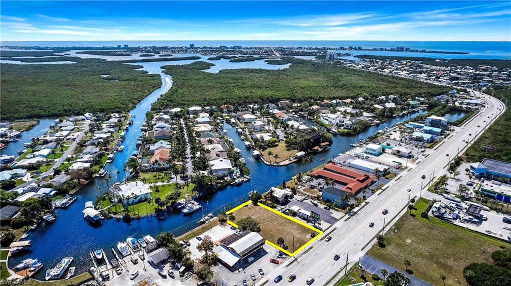 One or more photo(s) has been virtually staged, AI generated or rendered.  One or more photo(s) has been virtually staged, AI generated or rendered. GULF ACCESS CANAL COMMERCIAL PARCEL. Discover a standout commercial opportunity at 17721 San Carlos Boulevard—a wide canal-front parcel on the mainland side just before the Matanzas Pass Bridge to Fort Myers Beach. This vacant C-2 zoned property allows for a diverse range of commercial uses, including marine services, boat rentals, retail, convenience stores, medical or professional offices, and potential multifamily development. Positioned along a major corridor, the site offers exceptional visibility and steady traffic flow, providing consistent exposure to both residents and beach-bound visitors. The canal frontage adds significant value with direct access to the Gulf of America, making it especially attractive for marine-focused or waterfront-oriented businesses. As Fort Myers Beach continues its transformative redevelopment, demand is increasing for well-located commercial properties like this. Whether you're planning a marine service hub, retail concept, waterfront café, or mixed-use development, this property offers a flexible foundation for long-term success. Refer to Lee County’s Division 6 Commercial Districts code for the complete list of permitted uses. Don’t miss this rare opportunity to secure a prime waterfront position in one of Southwest Florida’s most active and evolving growth corridors