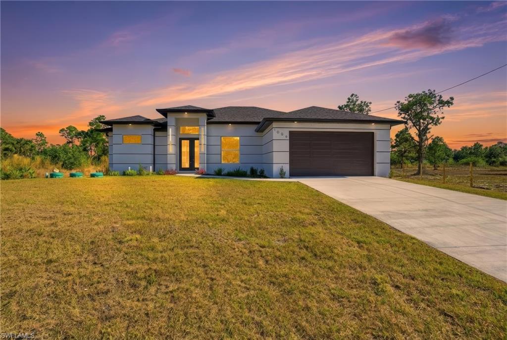 Seller offering $10,000 toward buyer closing costs — and will also include an outdoor refrigerator and whole-house water softener system.
A thoughtfully designed brand-new construction home offering modern style, open space, and everyday functionality on a spacious half-acre lot in Lehigh Acres.
This 1,950-square-foot home features 11-foot ceilings, 8-foot interior doors, and impact-resistant windows and doors, creating a bright, airy feel throughout. Polished porcelain flooring runs seamlessly through the home, complementing the clean, contemporary design.
The kitchen is the heart of the home, centered around a striking waterfall island, a dedicated wine closet, double wall ovens, and ample storage and workspace for daily living and entertaining. The open layout flows naturally into the living and dining areas, making the space feel connected and inviting.
With 4 bedrooms and 3 full bathrooms, the layout offers flexibility and privacy. One bedroom functions as a junior suite with its own bathroom and direct outdoor access, allowing it to serve as a future pool bath if a pool is added. All closets throughout the home feature custom cabinetry, adding both style and practical storage.
The primary suite provides a comfortable retreat with generous space, offering his-and-hers closets and modern finishes. A separate laundry room adds convenience and functionality. Outside, the screened-in lanai includes a full outdoor kitchen and outdoor shower, perfect for enjoying Florida living year-round. The half-acre lot offers ample room for a pool or outdoor expansion.
Modern, well-built, and designed for real life — this home stands out for its quality, space, thoughtful details, and includes a full irrigation system to support easy outdoor maintenance.