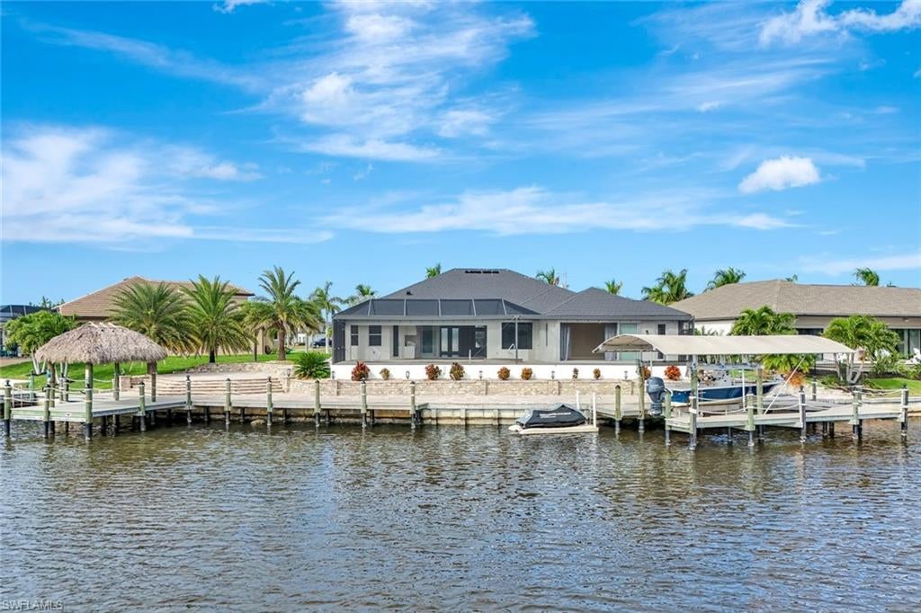 Prepare to be captivated by this stunning, 4-bedroom with 3-bathroom, 2900+ sq ft luxury residence; a testament to craftsmanship by local custom builder Aubuchon Homes. Situated on a highly desirable, *OVERSIZED SOUTH-EASTERN REAR EXPOSURE GULF-ACCESS LOT* with *146 FT OF WATER FRONTAGE*, this property offers the quintessential Southwest Florida lifestyle and a *BREATHTAKING VIEW THAT COMMANDS YOUR ATTENTION!*.  Features include a great-room style floorplan with vaulted and volume ceilings, 90° sliding glass door, wood cabinetry in kitchen with stainless steel appliances and granite countertops, gas stove with hood, bar, large primary bedroom with sitting area, ample closet space, and tile flooring in the main living areas with plenty of natural light flowing through the home. Exterior features include metal roof (2022), paver walkways and gutters around entire perimeter, 30 AMP generator transfer switch, whole-house reverse osmosis system, and mature palm trees.  Peace of mind comes standard with a remarkable 10-foot elevation!  Step outside to an *ENTERTAINER'S PARADISE* featuring an *INCREDIBLE OUTDOOR LIVING SPACE* with a heated saltwater pool and spa, all enclosed by a pool cage (2022) boasting picture-frame screens to maximize your panoramic waterfront views. For the avid boater, the amenities are second to none, including a boat dock and lift (13k lbs installed in 2020) with a canopy and composite decking, and your own private tiki hut (2022)!  The *EXPANSIVE HARDSCAPE AREA WRAPS THE ENTIRE REAR OF THE PROPERTY*, providing the *PERFECT* space for gatherings.  This property is more than a home; it’s a statement of luxury, convenience, and unparalleled waterfront living!
