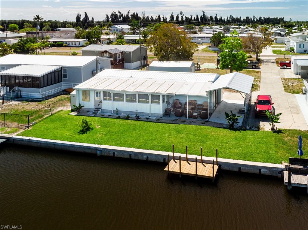 Waterfront opportunity in Flamingo Bay! This newly renovated 2-bedroom, 1-bath mobile home offers durability, thoughtful upgrades, and peace of mind. Built with a solid 3/4" plywood subfloor and plywood interior walls, the home is exceptionally well-constructed. Following prior hurricane flooding, the property has been fully remediated by the seller. Inside, you’ll find an upgraded kitchen featuring modern cabinetry and granite countertops. Comfort is ensured year-round with new mini-split A/C and heating units in every room, including the enclosed back porch, which boasts new tile flooring. The home has also been elevated 16 inches to help prevent future water intrusion. Exterior improvements include the replacement of original aluminum siding with plywood and Hardie plank siding for enhanced strength and longevity. The backyard has been refreshed with new sod and an irrigation system, creating a great space to relax or entertain. Boaters will appreciate the updated seawall and cap (2020) along with a brand-new dock (2026), offering easy waterfront access. Ideal as a weekend getaway, vacation rental, or full-time residence—this property combines coastal charm with practical upgrades. Voluntary HOA of $275 per person per year gives access to boat landing, clubhouse, new saltwater pool and amenities. Initial fee of $500 due upon joining HOA. Opportunity to purchase lot to the south for sale by separate seller would give buyer full lot from street to canal front.