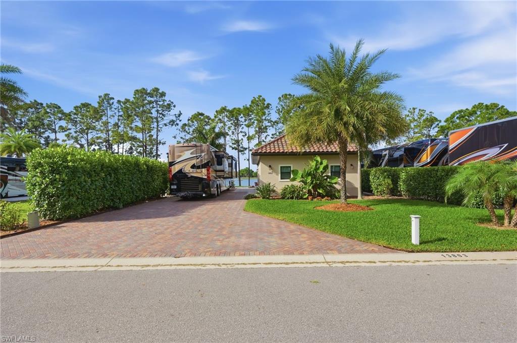 Welcome to your private retreat where indoor comfort meets elevated outdoor living and includes a Brand New Bintelli Golf Cart!! This beautifully appointed coach cabana features an extended 22’ x 22’ screened enclosure—six feet longer than standard—creating the perfect space for entertaining or relaxing year-round. The outdoor living area is designed for comfort and style with a built-in outdoor kitchen, elegant patio lighting, and an impressive collection of furnishings. Inside the vaulted-beam lanai, thoughtful design continues with a light rail and rope lighting accenting the kitchen area. The chef-inspired kitchen is outfitted with GE induction cooktop, GE built-in microwave/convection oven with full-size convection oven, GE dishwasher, Bosch French-door refrigerator with ice maker and interior water dispenser, and a Zephyr exhaust hood. Convenience meets quality with a point-of-use water heater, reverse osmosis water system serving both the sink and refrigerator, soft-close cabinetry with pull-outs, and floor-to-ceiling pantry cabinets. The living area creates a warm focal point with a 45-inch fireplace and mantel set against a dramatic floor-to-ceiling brick feature wall, complimented by a tray ceiling. There are Bali custom roller shades on the French doors and sidelights. The flexible living space includes a sleep sofa and a queen Murphy bed, making it ideal for hosting overnight guests. Technology and comfort are seamlessly integrated with WiFi-enabled clear shades, hurricane screens, DC WiFi ceiling fans, and an Ecobee smart thermostat. Plantation shutters enhance every window, while a whole-home water softener adds everyday convenience. The coach cabana is all-electric, with LP tanks serving the grill and fire table. The rear storage area is exceptionally functional, featuring an LG WashTower, built-in cabinets, butcher-block counter, and a 7-foot entry door providing access to a large open storage area. Outdoor enthusiasts will appreciate the included kayak stand and fishing kayak, perfect for enjoying the 22 acre lake. This thoughtfully upgraded property blends luxury finishes, smart technology, lush landscaping and indoor/outdoor living—making it an ideal place to relax, entertain, and enjoy the Southwest Florida Motorcoach lifestyle. Located within Golden Palms Luxury Motorcoach Resort you will enjoy access to a stunning clubhouse, saltwater pool, hot tub, sauna, and exercise room. There are plenty of activities for everyone and every interest including pickleball, cornhole, fishing, kayaks, paddleboats, and a 1 acre dog park. You will be surrounded by nature, yet only a short drive to restaurants, shopping, parks, golf, airport, Baseball Spring Training Stadiums, and SWFL Beaches. The Resort is a fabulous place for your Class A, Super C, and even your stacker trailer if painted to match the motorcoach. Let's make this special property your very own piece of paradise