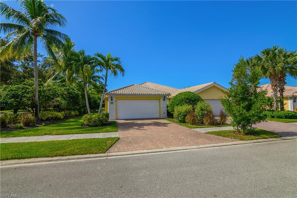 One or more photo(s) has been virtually staged, AI generated or rendered.  The Ultimate Florida Escape in VeronaWalk! This popular DiVosta-built Capri model attached villa is constructed with solid poured concrete, is not in a flood zone, and offers a bright, open split-bedroom floor plan designed for comfortable Florida living. Meticulously maintained and recently upgraded from top to bottom, this move-in-ready home features 2 bedrooms plus a versatile den, 2 beautifully updated bathrooms, and an attached 2-car garage. Enjoy a fresh feel throughout with newly installed luxury vinyl plank flooring, fresh interior paint, new lighting fixtures, and ceiling fans. Soaring vaulted ceilings and a wall of windows fill the spacious living room and flexible den with abundant natural light. The centrally located, open-concept kitchen features sleek quartz countertops, a split sink, a garbage disposal, and stainless steel appliances. A separate, fully equipped laundry room offers cabinetry, a utility sink, a glass block window, and a pantry closet, complemented by an abundance of storage closets found throughout the home. Sliding glass doors lead out to a covered, screened lanai, creating the ultimate private setting for relaxing or entertaining. Located within VeronaWalk, an award-winning, 24-hour guard-gated community in Naples known for its active lifestyle, scenic bridges, sparkling lakes, and beautifully landscaped streets. Residents enjoy an impressive array of amenities, including a resort-style pool, lap pool, fitness center, tennis, pickleball, bocce, basketball courts, miles of walking and biking paths, and a vibrant Town Center featuring a restaurant, café, ice cream and coffee shop, beauty salon, post office, gas station, library, and travel agency. A bustling social calendar is supported by low HOA fees, and the community is conveniently located just a short drive from downtown Naples, Marco Island, pristine beaches, premier shopping, fine dining, and healthcare.