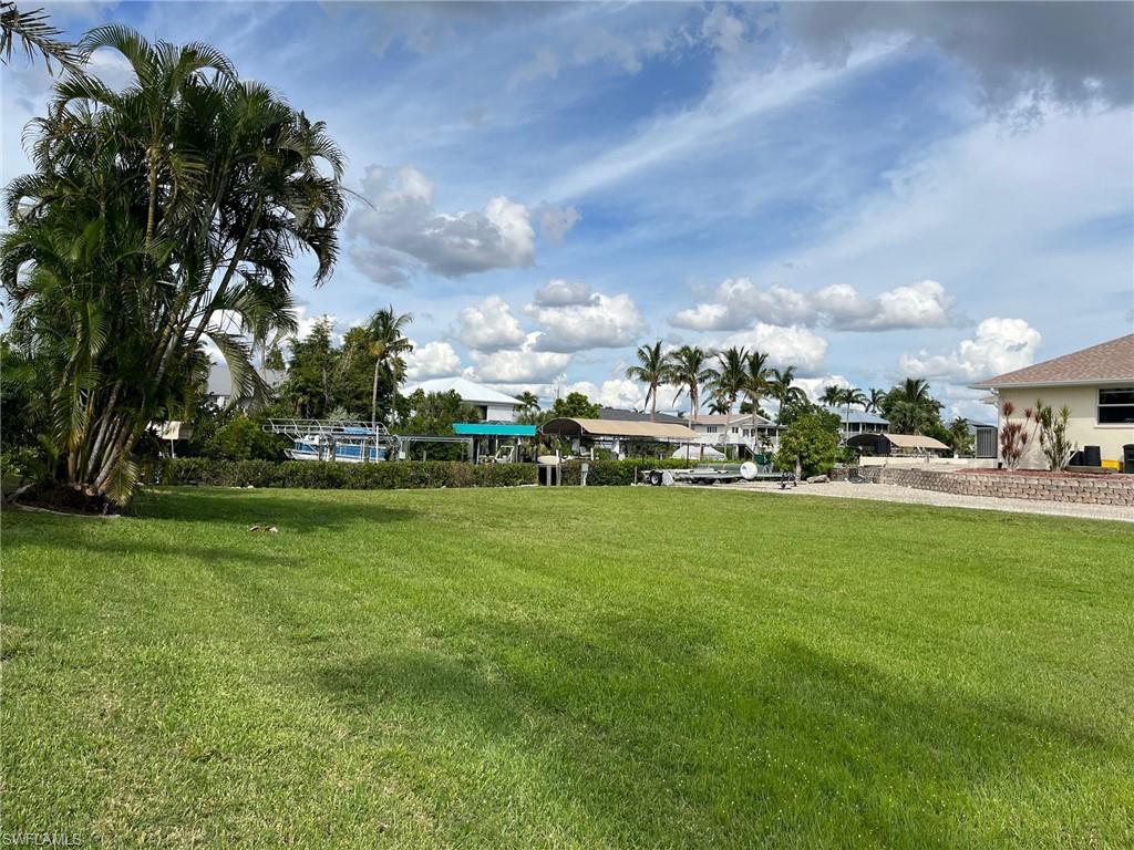 Imagine building your dream coastal home where boating, fishing, and island living are part of everyday life! Welcome to 5414 Martin Cove, a cleared waterfront homesite with electric in place, offering approximately one-third of an acre in the desirable Serenity Cove neighborhood of Bokeelia on Pine Island. Enjoy direct Gulf access with no bridges and an existing dock and boat lift, saving you the expense and hassle of starting your waterfront improvements from scratch! The boat lift was updated in 2023 with new cables, bunks, and one motor, making this property especially appealing to boating enthusiasts. The shoreline features riprap and a natural mangrove hedge, adding to the tropical island setting. Picture a beautiful elevated coastal home with spacious porches, room for entertaining, and your boat waiting just steps away. A conceptual home rendering is included to help you envision the possibilities! Spend your days exploring Pine Island Sound, Charlotte Harbor, Cayo Costa, Sanibel, Captiva, and the surrounding waterways, then return home to the peaceful charm of island living. Whether you're planning a full-time residence, seasonal retreat, or future retirement getaway, this waterfront property offers an exciting opportunity to create your own slice of paradise. Seller financing may be considered with acceptable terms. Don't just dream about the island lifestyle—start planning it today!