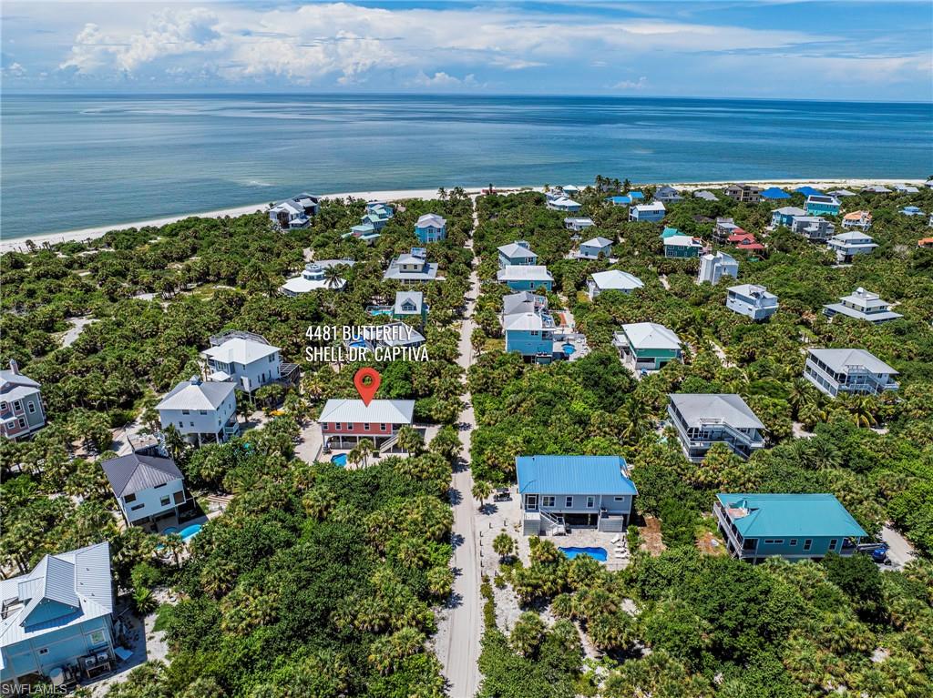 A Must See! Great Opportunity. North Captiva, private heated saltwater pool, Gulf-side location, turnkey furnished, rental history and 150+ five-star guest reviews. 64k in rentals in 2026 alone to date! Welcome to “The Perfect Shell,” a fabulous turnkey island beach home offering an exceptional south Gulf-side location, private heated saltwater pool, easy beach access and impressive vacation-rental history with 150+ five-star reviews! Situated on a desirable high-and-dry lot in Captiva Dunes, this charming stilt home is just a short walk or golf-cart ride to the wide sugar-sand shoreline of Sunset Beach, known for spectacular sunsets, shelling, fishing, swimming and sandbars. Additional prime surrounding lots may be available for purchase by the buyer, offering a unique opportunity for added privacy or expansion. STRAP: 05-45-21-08-00000.0350 & 05-45-21-08-00000.0090  Inside, a bright, open great-room floor plan captures beautiful tropical views and opens to an expansive screened front balcony with sliders, ceiling fan and recessed lighting. The home offers 2 bedrooms and 1.5 baths and is sold turnkey furnished with lovely furnishings, fixtures and window coverings. The kitchen features a long breakfast bar, Corian countertops, recessed lighting, appliances and gas range. The primary bedroom includes a large closet. The main bath offers a large tiled shower and Corian-topped vanity. The half bath includes a sink, extensive built-in cabinetry, countertops and full-size stacked washer/dryer, with potential for a second full bath if desired. Outside, the large heated saltwater pool features built-in seating shelves, aluminum fencing and expansive brick-paver decking with wonderful sun exposure. A generous side yard provides additional outdoor space and room to expand. The spacious under-house area offers even more possibilities for entertaining—add an outdoor shower, changing area, bath, bar or outdoor kitchen. Enjoy the best of island living with exceptional outdoor space, tropical surroundings and easy access to one of North Captiva’s most beautiful beaches. Great property layout with a large side yard, pool area and room to expand—an increasingly special combination on the island. Simply a must-see! Recent improvements and features include a 2024 white standing-seam metal roof, 2023 HVAC, 2025 exterior paint, 2023 whole-house reverse-osmosis system, hurricane-impact windows and doors, Hardie-board siding, tile throughout and attached ground-level garage. For buyers interested in vacation-rental income, The Perfect Shell has an established rental history with many repeat annual guests. The property is professionally managed, with continued management available. Best of all, this is a private pool home with no HOA fees or club membership to assume! Whether you're looking for your own North Captiva getaway, an established vacation-rental property, or a combo of personal enjoyment & income potential. Exceptional location.