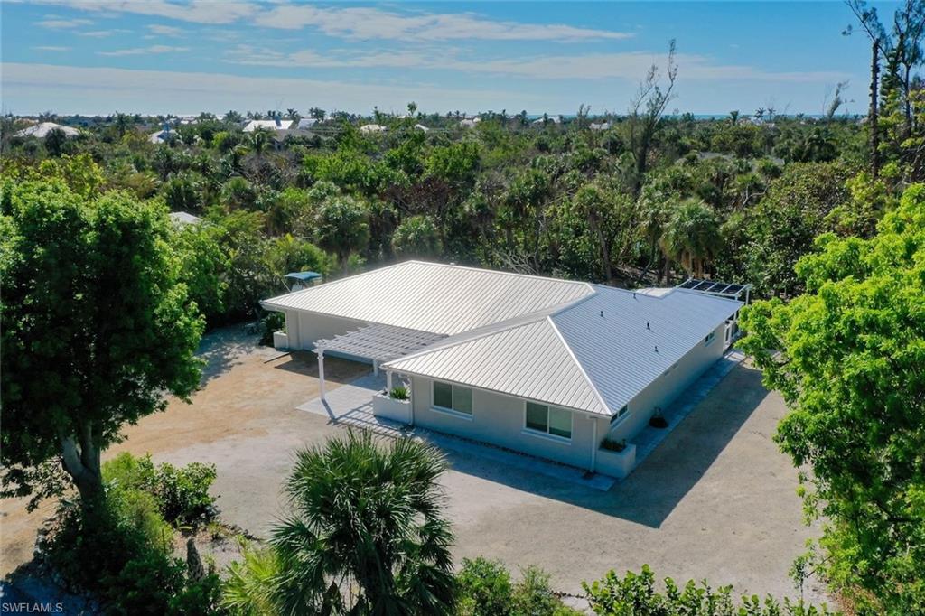 Tucked along one of the highest ridges in the Sanibel Bayous, this 3-bedroom, 2.5-bath sits at 9 ft. of base elevation, giving you rare peace of mind in a ground level home on the island. Step inside to a bright, modern interior where the kitchen shines with sleek countertops, stainless-steel appliances and crisp white cabinetry, all opening to an airy living space. Pocketing sliding glass doors and large windows dissolve the line between indoors and out, leading straight to your private pool surrounded by lush tropical greenery. Mornings start with a short bike ride to Bowman’s Beach, consistently ranked among Sanibel’s best for shelling, sunsets and quiet stretches of sand. Evenings end poolside, listening to the island settle in around you. Whether you’re a beachcomber, a nature lover or simply looking for a quiet escape, this home delivers the Sanibel lifestyle you’ve been waiting for.