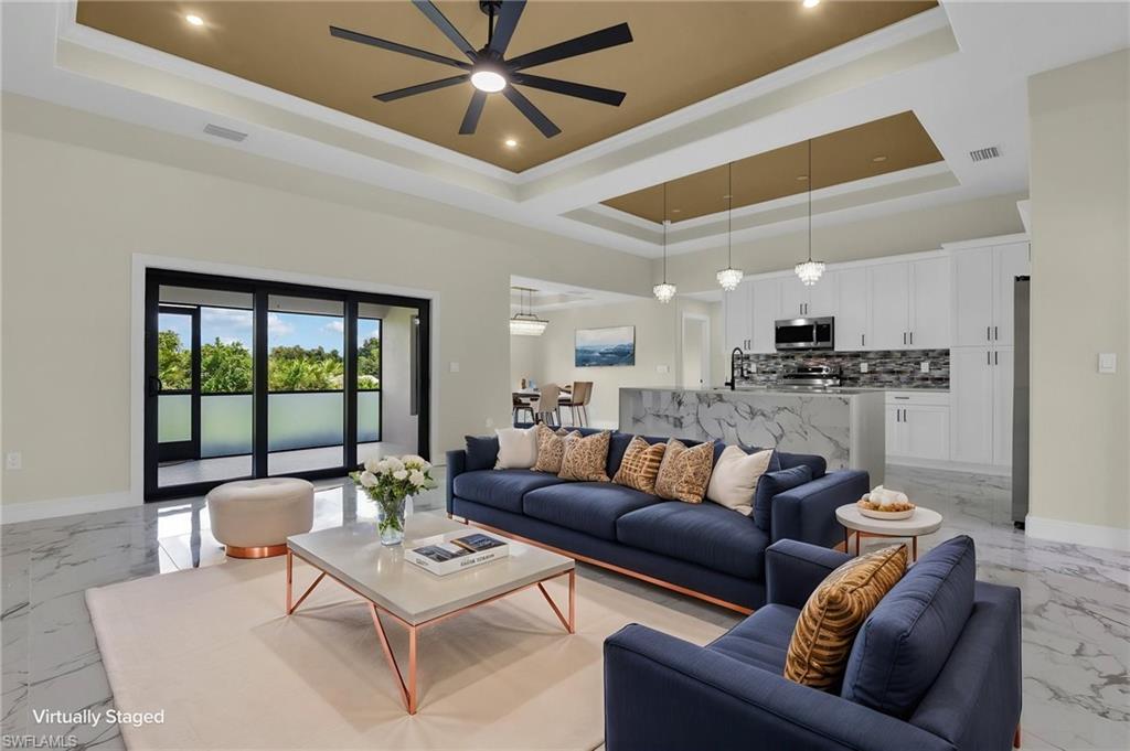 One or more photo(s) has been virtually staged, AI generated or rendered.  This spectacular 4-bedroom, 2-bathroom home is superbly built and situated on a large lot, offering exceptional space, privacy, and endless possibilities. Designed with both comfort and style in mind, contemporary home features a spacious, open-concept living area enhanced by elegant tile flooring throughout, abundant natural light, and modern LED lighting. Stylish and elegant tray ceiling elevate the open-concept living space, complemented by recessed LED lighting that create a bright, airy atmosphere. The gourmet kitchen stands out with stunning quartz countertops, quality wood cabinetry, and ample workspace, making it the perfect gathering spot for family and friends; stainless steel appliances are included. The spacious primary suite serves as a private retreat, featuring a large walk-in closet and a luxurious oversize bathroom with a deep soaking tub and separate shower, all accented by contemporary LED-lit mirrors. Step outside to enjoy the expansive paved lanai, which is already equipped with sink, metal framing and quartz countertop, water and electrical hookups, making it ready for the outdoor kitchen and entertainment area of your dreams. The northwest-facing rear orientation provides beautiful afternoon light and spectacular sunset views. With generous indoor and outdoor living spaces and premium finishes, this property offers the perfect blend of elegance, functionality, and the best of the Lehigh Acres lifestyle.