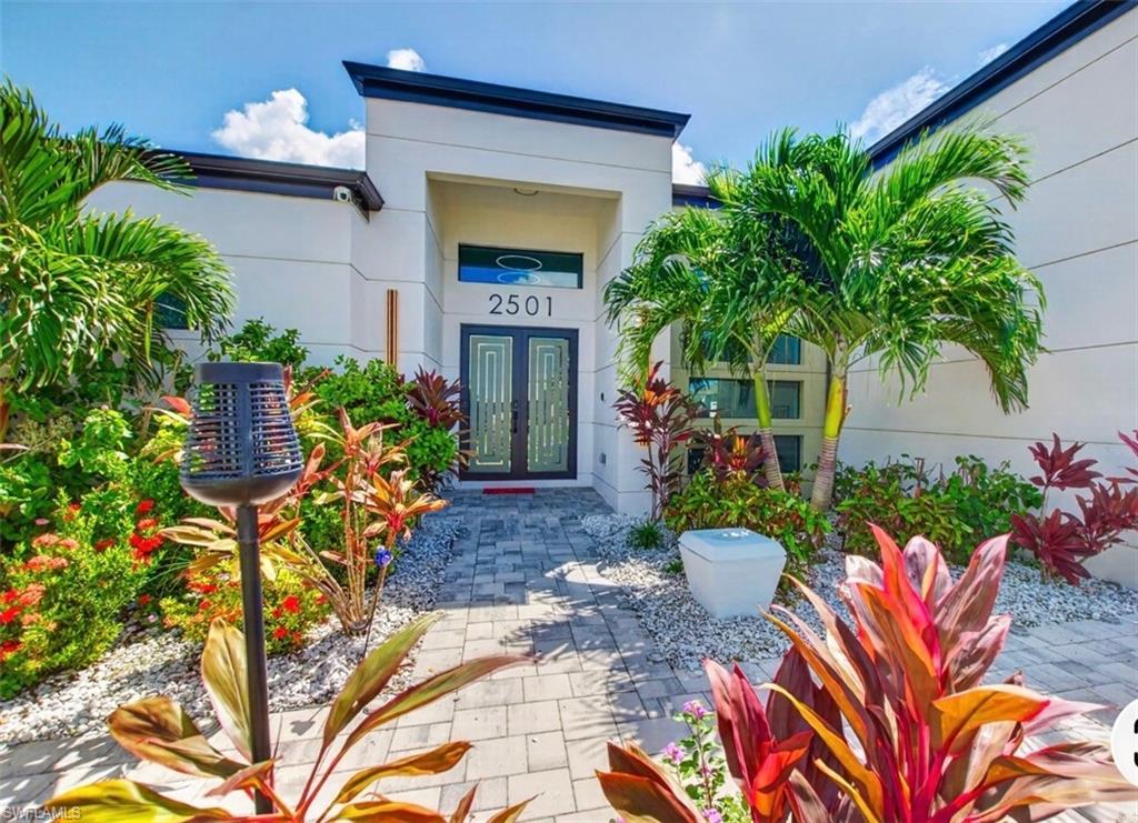Experience elevated Florida living at 2501 SW 23rd Place, where sophisticated design, generous living spaces, and resort-inspired outdoor amenities come together on an corner lot in desirable Southwest Cape Coral.

This beautifully appointed residence offers 3 spacious bedrooms, a private den/office, 2 full bathrooms, a half bath, and an expansive 3-car garage, thoughtfully designed for both everyday comfort and effortless entertaining. Step inside to an inviting open-concept floor plan filled with natural light, where the gourmet kitchen flows seamlessly into the expansive living and dining areas, creating an impressive central gathering space.

The primary suite offers a private retreat with a spa-inspired ensuite designed for relaxation. Enjoy dual vanities, a soaking tub, an oversized walk-in shower with dual shower heads, and two generous walk-in closets, combining luxury with exceptional functionality.

Two additional bedrooms provide comfortable accommodations for family or guests, while the private office with stylish barn doors creates a dedicated work-from-home space. The home's flexible layout provides additional opportunities for a media room, playroom, sitting area, or personalized retreat.

Designed to embrace the Southwest Florida lifestyle, the outdoor living area is truly an extension of the home. Step through to your own private screened oasis, complete with a custom swimming pool accented by tranquil waterfall features, an expansive covered lanai, and a fully equipped summer kitchen featuring a built-in BBQ grill and beverage cooler. An outdoor shower adds another thoughtful touch for days spent relaxing poolside or entertaining guests.

Additional highlights include City Water and Sewer already in place (Assessments Paid) a spacious three-car garage, abundant storage, and a beautifully designed indoor-outdoor living experience.

From sophisticated interiors to resort-style outdoor entertaining, 2501 SW 23rd Place delivers an exceptional combination of luxury, space, comfort, and the relaxed elegance of the Cape Coral lifestyle. Whether hosting unforgettable gatherings, enjoying quiet evenings by the pool, or simply settling into your own private retreat, this home was designed to make everyday living feel extraordinary.