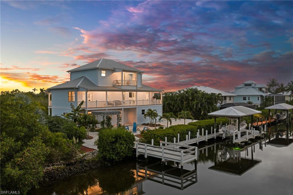 Tucked away in the private waterfront community of Buttonwood Key, this custom-built 2024 home combines privacy, thoughtful design and the ultimate Pine Island boating lifestyle. **Designed with 2 bedrooms plus 2 versatile bonus rooms, the home offers flexible spaces that can easily function as guest quarters, home offices, a den, hobby or craft rooms, or additional sleeping areas—allowing the home to live much larger than a traditional 2-bedroom floor plan.** Set in a serene location with protected preserve views across the front and beautiful water views from the rear, this home was designed to take full advantage of its surroundings. The ground level offers an impressive air-conditioned 4-car garage with workshop area, mudroom and abundant space for vehicles, boating gear and island toys. An additional outdoor storage shed tucked beneath the deck provides even more convenient space for tools, fishing gear and outdoor equipment. Step outside to your own waterfront retreat featuring a composite dock, boat lift, separate sitting dock, built-in fire pit and pergola—an inviting setting to relax by the water after a day of boating. The tropical landscaping adds to the island atmosphere with banana and mango trees along with established aloe plants. Quick access puts you within easy reach of Pine Island Sound, the Gulf, beaches and some of Southwest Florida’s renowned fishing and boating destinations. The main living level features 10’ ceilings, shiplap walls and an open great room designed around expansive water views. The kitchen features white raised-panel cabinetry, granite countertops, stainless steel appliances, a center island and a spacious pantry with built-in shelving and cabinetry. This level also includes a guest bedroom and bath, laundry room with cabinetry and utility sink, sunroom and sitting area, along with the home’s flexible bonus spaces. Front and rear balconies extend the living space outdoors and capture both the peaceful preserve setting and waterfront views. The third level is dedicated to a private primary retreat featuring its own waterfront balcony, two walk-in closets—including one currently utilized as a craft space—and a spacious bath with dual vanities, soaking tub and an impressive walk-in shower with multiple shower heads and rain shower. Smart-home features add everyday convenience with connected lighting, A/C system, appliances and garage doors, while the drinking water system includes reverse osmosis at the tap. With room to add a pool, incredible garage and storage space, flexible bonus rooms, multiple indoor and outdoor living areas, tropical fruit trees and direct access to the water, this is much more than a home—it’s a private island retreat designed for those who want space, serenity and boating right outside their door.