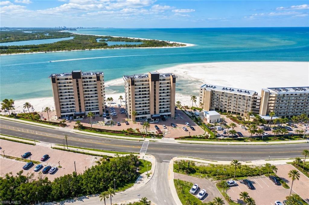 Beautifully renovated end-unit condo in desirable south Estero Island! Located in Building 8400, this bright and spacious first-floor unit features extra windows, beautiful views of Carlos Pass and the Gulf, and convenient access to the parking garage, beach, and pool. Enjoy an expansive entry porch, enclosed lanai for additional living space, and a side deck perfect for relaxing or grilling. The upgraded kitchen offers additional cabinetry and storage, plus a full-size washer and dryer. New hurricane sliders and Wi-Fi-enabled hurricane shutters add modern convenience. Building 8400 offers a peaceful setting away from bridge traffic noise. Walk to Lovers Key State Park, beautiful beaches, restaurants, and shopping. Enjoy the community's private dock for fishing or relaxing by the water. With extensive renovations and desirable indoor and outdoor living spaces, this exceptional condo is ideal for a beach getaway, full-time residence, or potential investment property. See separate list of renovations for additional details!