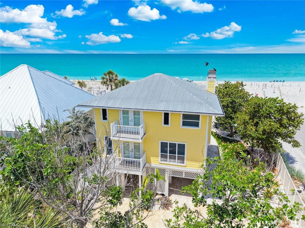 Be captivated in Captiva Island at this extraordinary Gulf-front retreat, perfectly positioned along one of the island’s most coveted beachfront settings near the heart of Captiva Village. Just moments from boutiques, restaurants, marinas, and island entertainment, this exceptional residence offers the ideal blend of privacy, luxury, and breathtaking Gulf sunsets.

Completely reimagined with impeccable craftsmanship and designer finishes throughout, the home seamlessly blends sophisticated elegance with relaxed coastal living. Expansive impact-rated glass doors fill the interiors with natural light while framing panoramic water views from nearly every room. Inside, thoughtfully designed living spaces feature beamed ceilings, rich hardwood flooring, custom millwork, and dramatic fireplaces that add warmth and character.

The gourmet chef’s kitchen is designed for entertaining and everyday living alike, showcasing custom high-gloss cabinetry, premium appliances, designer stone surfaces, and an oversized gathering island. Outdoor living is equally impressive, with multiple screened and open lanais, inviting lounge and dining spaces, sun decks, and a fully equipped summer kitchen overlooking the beach and Gulf waters.

Upstairs, guests enjoy a private suite opening to a spectacular beachfront terrace, while the luxurious primary suite offers a spa-inspired bath, bespoke finishes, private viewing deck, and statement fireplace. Extensive upgrades include Hardie-board siding, a metal roof, Trex decking, updated electrical and plumbing systems, a floating architectural staircase, retractable sun screens, brick-paver driveway, lush tropical landscaping, and curated designer furnishings throughout.

Residents also enjoy resort-style amenities including a bayside marina and boat dock, tennis courts, and a large community pool. With strong weekly rental potential, this fully renovated beachfront retreat presents a rare opportunity to own a luxury island escape in one of Southwest Florida’s most sought-after communities. Luxury, privacy, views, and lifestyle come together beautifully in Captiva.