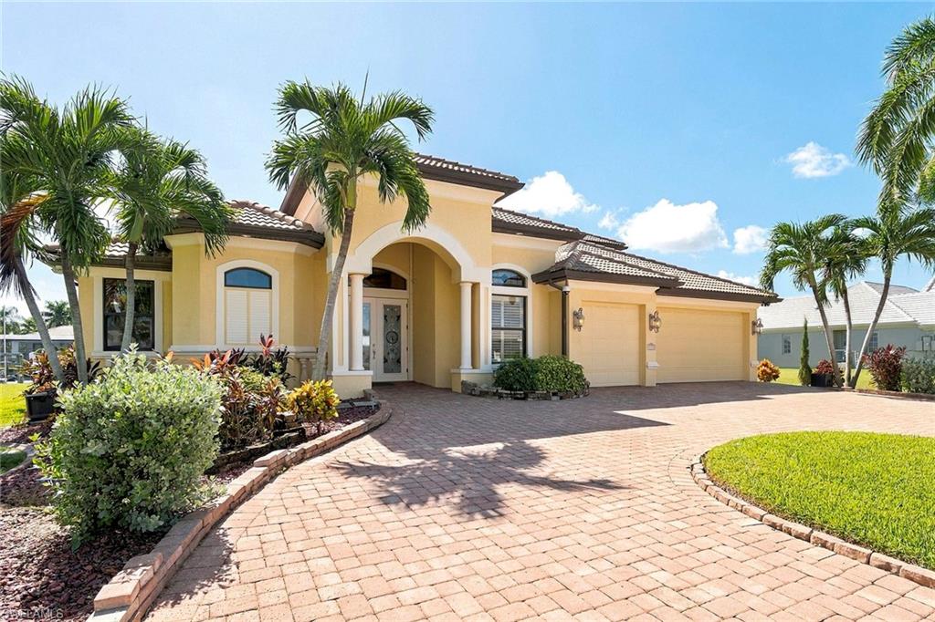 Welcome to an exceptional Cape Coral waterfront residence offering 160 feet of waterfront, direct Gulf and Bimini Basin access with no bridges, expansive water views and an adjacent lot included in the sale. On a broad canal and positioned with views toward another large canal, the home enjoys an unusually open waterfront perspective, along with front-row views of holiday boat parades that travel directly past the property. Built in 2008, the home was thoughtfully designed for indoor-outdoor Florida living. Dramatic disappearing corner sliders and fully pocketing downstairs sliders open the main living areas to the spacious lanai, pool, spa, and covered outdoor kitchen and bar, creating an entertaining space designed to be enjoyed in virtually any weather. The adjoining second lot connects directly to the outdoor living area and offers remarkable additional space for lawn games, a garden, pets or simply added privacy. Mature landscaping and established privacy plantings complete the setting. The first-floor primary suite features two walk-in closets, direct lanai access through a fully pocketing slider, and a spacious bath with a soaking tub, spacious separate shower and multiple showerheads. Two additional downstairs en-suite bedrooms provide excellent guest accommodations, including a guest suite with direct pool access. Soft-close cabinetry and drawers are found throughout the home, and the washer and dryer are included. Upstairs offers exceptional flexibility, with a large bonus room designed equally well as an executive home office, media room or private entertainment retreat. A convenient galley kitchen makes the space especially well-suited for extended work sessions or hosting. The second floor also includes a spacious private bedroom, full bath, and screened terrace positioned by the architecture for added privacy while capturing the breeze and waterfront views. Storage has been carefully incorporated throughout the property, including substantial step-out attic storage above the garage, extensive garage storage, in-garage cabinetry, a dedicated overhead HVAC service and storage area, and an under-stair closet configured for wine storage and technology equipment. The oversized three-car garage accommodates vehicles as well as bikes, recreational equipment and smaller water toys. At the water, a composite dock, two boat lifts, and bridge-free Gulf/Basin access create an outstanding boating setup. The dock also provides convenient fishing directly from the property, while manatees are frequently seen in the surrounding waterways. City-supplied non-potable irrigation water economically and environmentally serves the landscaping. From the expansive waterfront and included second lot to the multiple guest retreats, abundant storage and resort-style outdoor living spaces, this property offers a rare combination of land, boating access, privacy and flexibility in the Cape Coral waterfront market.