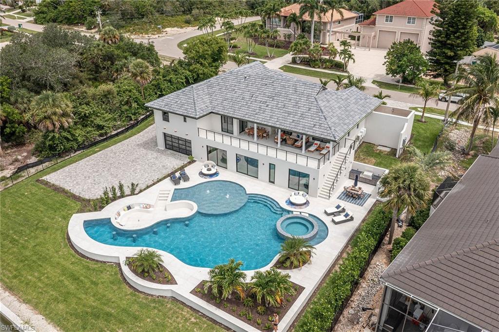 Completely updated in 2026, this six-bedroom home with high elevation and fast water direct access to the gulf offering luxury living. This beautiful home features abundant natural light, custom cabinetry throughout and a fully equipped appliance gourmet kitchen with a large island that opens to the great room with a striking fireplace feature wall. A spacious dining area flows seamlessly into the kitchen and dining space. The main level includes four bedrooms, one with private exterior access. It has a luxurious primary suite complete with a private outdoor shower. Enjoy the convenience of upstairs and downstairs laundry rooms. The walkout lower level is designed for entertaining, featuring two additional bedroom suites, a custom movie room with TV, popcorn station, refrigerator and built-in cabinetry, plus a full summer kitchen with island and dining space, all opening to beautiful pool and waterfront views. Additional gathering space includes serving cabinetry and towel storage. Go outside to a resort-style setting with a spectacular pool, large spa, fire bowl seating area, fountains, sunning space and expansive seating areas. An outdoor dining area with built-in grill and cabinetry enhances the experience, along with additional guest parking. The oversized air-conditioned garage downstairs showcases a custom floor, LED lighting and glass doors, and opens to a unique cigar/sports lounge with bar cabinetry, refrigerators and a half bath. The property is fully landscaped with a gated rear entry for added parking and garage access. In addition, there is an upstairs air-conditioned two-car garage that can also accommodate car lifts. Ideally located for boating enthusiasts with easy access to open water. With new mechanicals, roof, pool and interior finishes throughout, this home offers a blend of luxury, comfort and lifestyle.