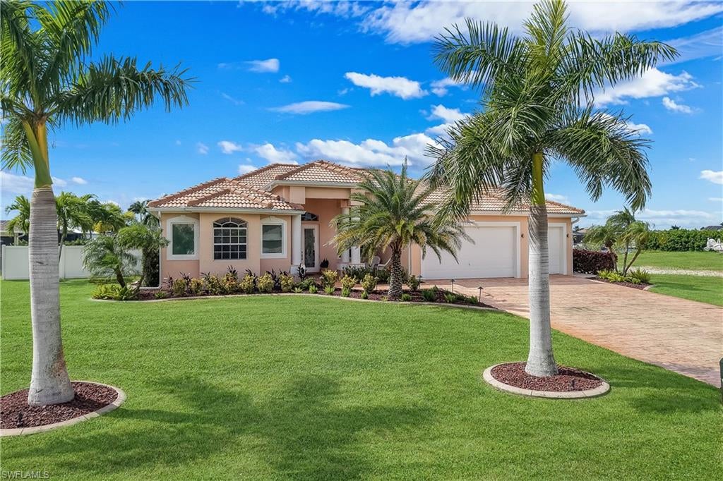 BRAND NEW 2026 KITCHEN, NEW FLOORING, GULF ACCESS, WESTERN EXPOSURE AND 240 FEET OF WIDE WATER VIEWS! Beautifully transformed with a stunning new kitchen and flooring throughout the main living areas, this exceptional waterfront residence offers 3 bedrooms, 3 bathrooms, 2,269 square feet of living space, a 3 car garage and an oversized 15,028 square foot lot along one of Cape Coral's impressive wide canals. From the moment you arrive, lush tropical landscaping, an expansive stamped concrete driveway, a beautiful barrel tile roof replaced in 2023 and inviting French entry doors create a striking first impression. Inside, soaring ceilings, decorative tray ceilings, transom windows, contemporary lighting and an abundance of natural light complement the home's fresh, modern coastal design. The completely renovated 2026 kitchen is a true centerpiece, showcasing beautiful white cabinetry, elegant countertops, a coordinating backsplash, sleek hardware, stainless steel appliances, generous storage and an expansive peninsula with seating that opens effortlessly to the dining and living areas. Large windows frame breathtaking waterfront views, while dramatic 90 degree pocket sliding glass doors create a seamless connection between indoor and outdoor living. The spacious primary suite offers private access to the lanai, an electric fireplace, dual walk in closets with custom built in shelving and an ensuite bathroom featuring dual vanities, a dedicated makeup counter, soaking tub and an oversized walk in shower with multiple shower heads. Two additional guest bedrooms provide comfortable accommodations, including one with its own ensuite bathroom. Step outside to your private waterfront retreat featuring a heated saltwater pool with cascading waterfall, a picture window screen enclosure, a beautifully tiled pool deck and a covered outdoor entertaining area complete with a summer kitchen, built in grill and refrigerator. Western rear exposure provides spectacular sunset views across the expansive 240 foot wide canal, while the private boat dock offers access to the Gulf for days spent exploring Southwest Florida's waterways. Additional improvements include a new roof, gutters, pool cage, lanai tile and extensive landscaping enhancements completed in 2023, kitchen appliances in 2024, and a new pool pump and motor in 2026. City water and sewer assessments are paid. Ideally situated in desirable Southwest Cape Coral near Cape Harbour, Tarpon Point Marina, waterfront dining, shopping and entertainment, this beautifully updated home delivers an extraordinary combination of waterfront living, modern design and the Florida lifestyle you've been looking for. Schedule your private showing today!