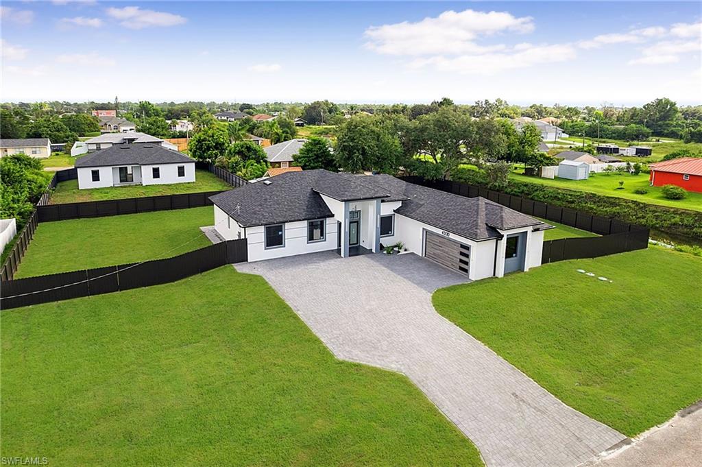 Seller is motivated and ready to make a deal! 10 Year Structural Warranty and 3% seller credit toward buyer’s closing costs. 100% completed and ready to move-in. Be sure to click on the 3D virtual tour! Set on a half-acre canal-front lot at the end of a cul-de-sac, this beautifully designed new construction home offers 1,855 sq ft of living space and 2,618 total sq ft with 3 bedrooms plus a den/office, 3 full baths, and a 2-car garage. Bring your boat or RV — there is room to park and play behind the fully fenced yard. Inside, 9'4" ceilings run throughout and rise to a dramatic 14'8" at the entry and foyer, with coffered ceilings in the primary suite and study. Hurricane-impact windows and doors, large-format porcelain tile, high-profile baseboards, recessed lighting, and sleek linear-slot A/C diffusers carry through every room. The kitchen is the centerpiece: custom flat-panel cabinetry with glass-front display uppers, a waterfall quartz island with a fluted feature front, a bookmatched full-height quartz backsplash, under-cabinet lighting, a tall pull-out pantry, and a stainless-steel appliance suite with double wall ovens, built-in microwave, cooktop, and French-door refrigerator. The living area is anchored by a linear fireplace feature wall and opens through sliding glass doors to a covered lanai overlooking the oversized yard. Custom closet cabinetry is built into every bedroom. The primary suite sits behind a designer barn door and features a coffered ceiling with a modern fan, two walk-in closets, and a spa-style bath with dual sinks, LED mirrors, a private water closet, and an oversized frameless shower with rain and handheld heads. Both secondary baths carry the same quartz finishes, glass shower doors, and premium matte-black fixtures. A dedicated laundry room includes the washer and dryer, cabinetry, and utility sink. Outside: circular pavered driveway, insulated glass-panel garage door, epoxy-finished garage floor, full irrigation, and fresh sod. Surrounded by new homes, this residence combines style, quality, and value. Don’t miss your chance!